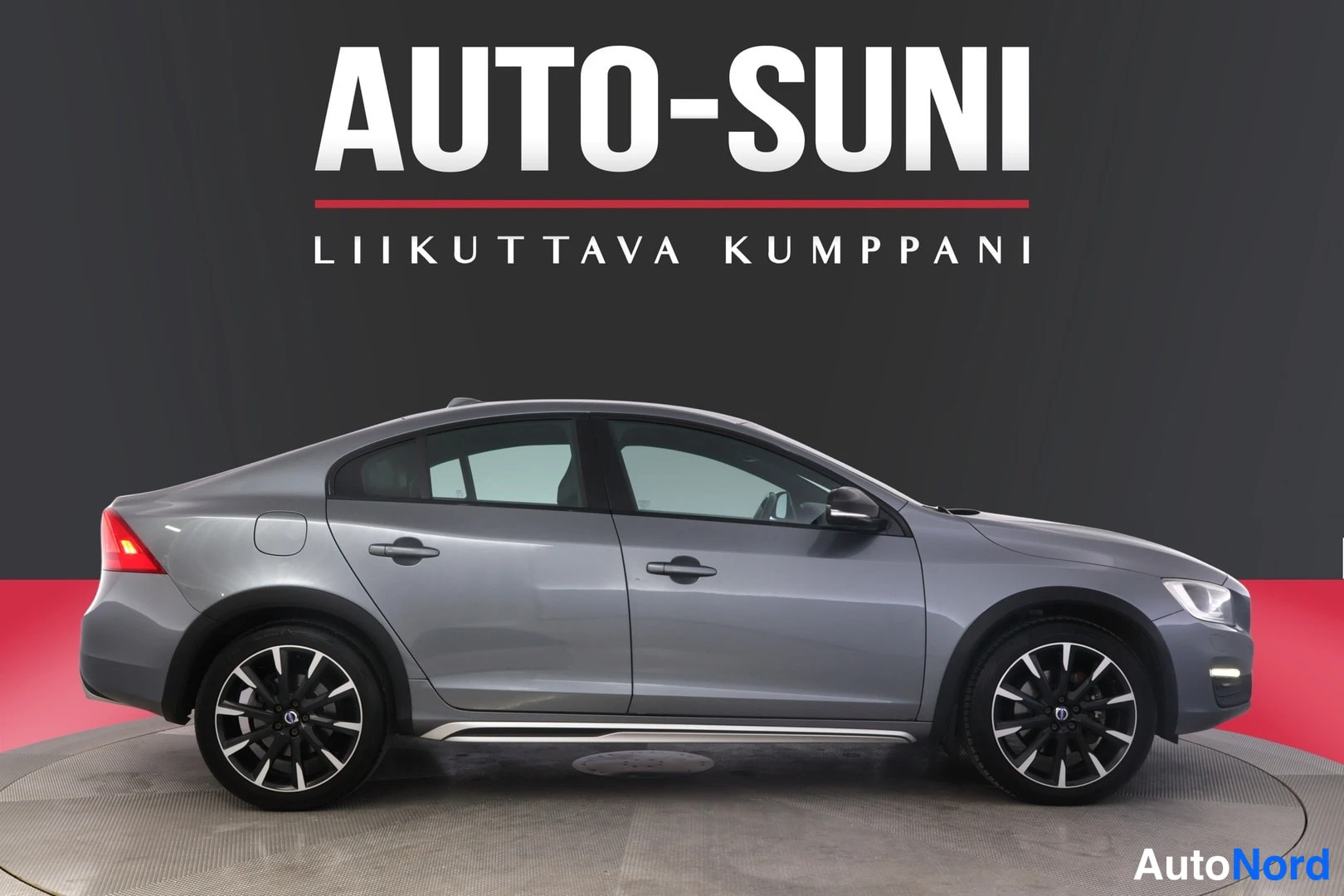 Sivulta: Auton sivukuva oikealta, harmaa sedan.