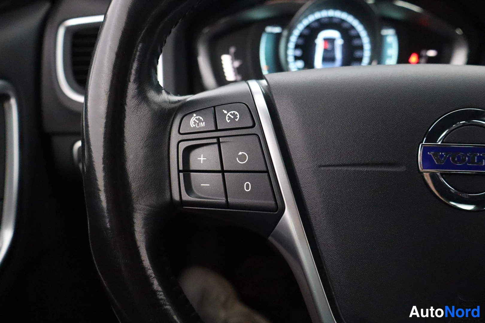 Yksityiskohta: Ohjauspyörän vasen puoli lähikuvassa. Näkyvillä Cruise Control -painikkeet (LIM) ja painikkeet merkkivalojen säätöön.
