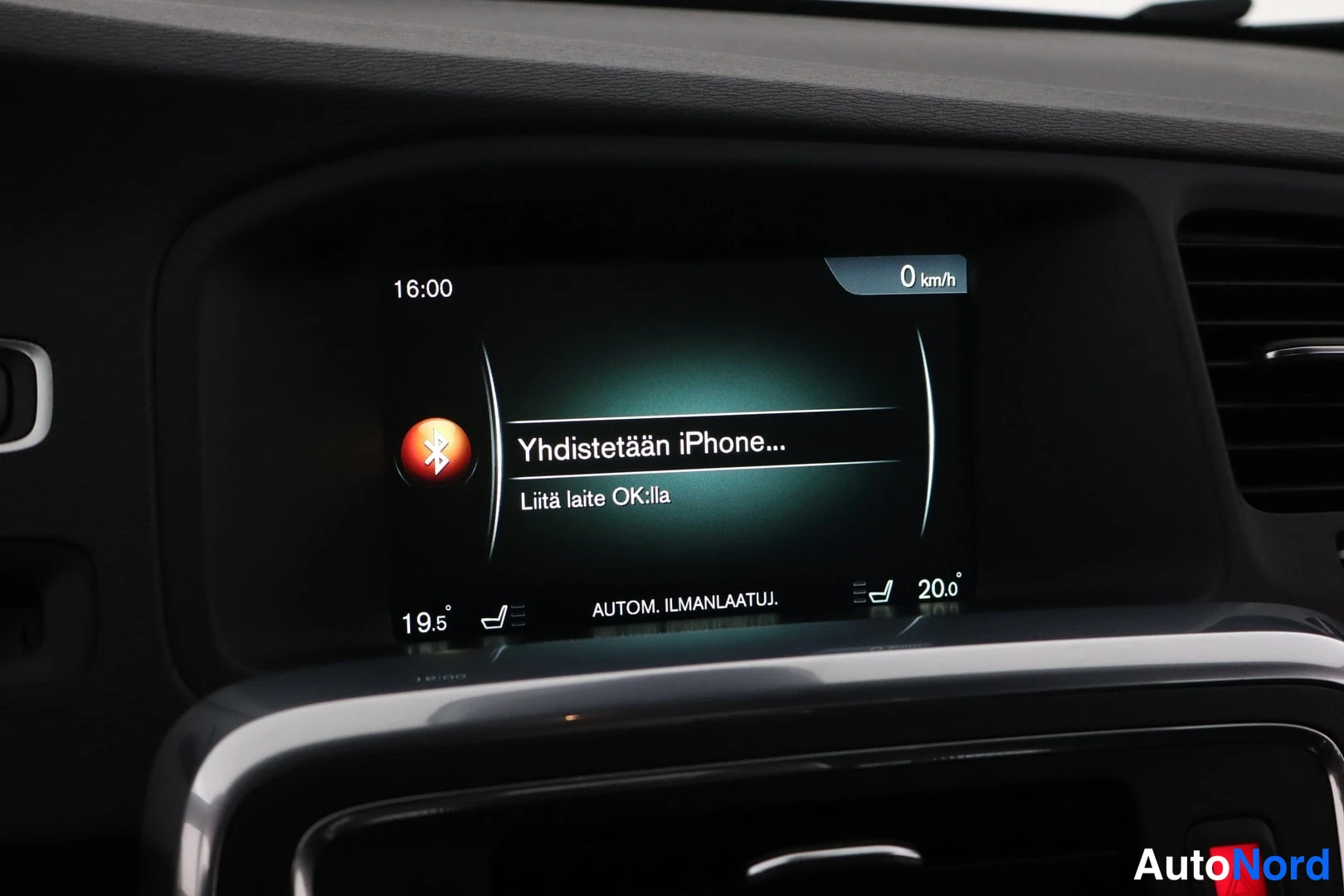 Yksityiskohta: Infotainment screen displaying Bluetooth connection interface for iPhone pairing in Finnish language