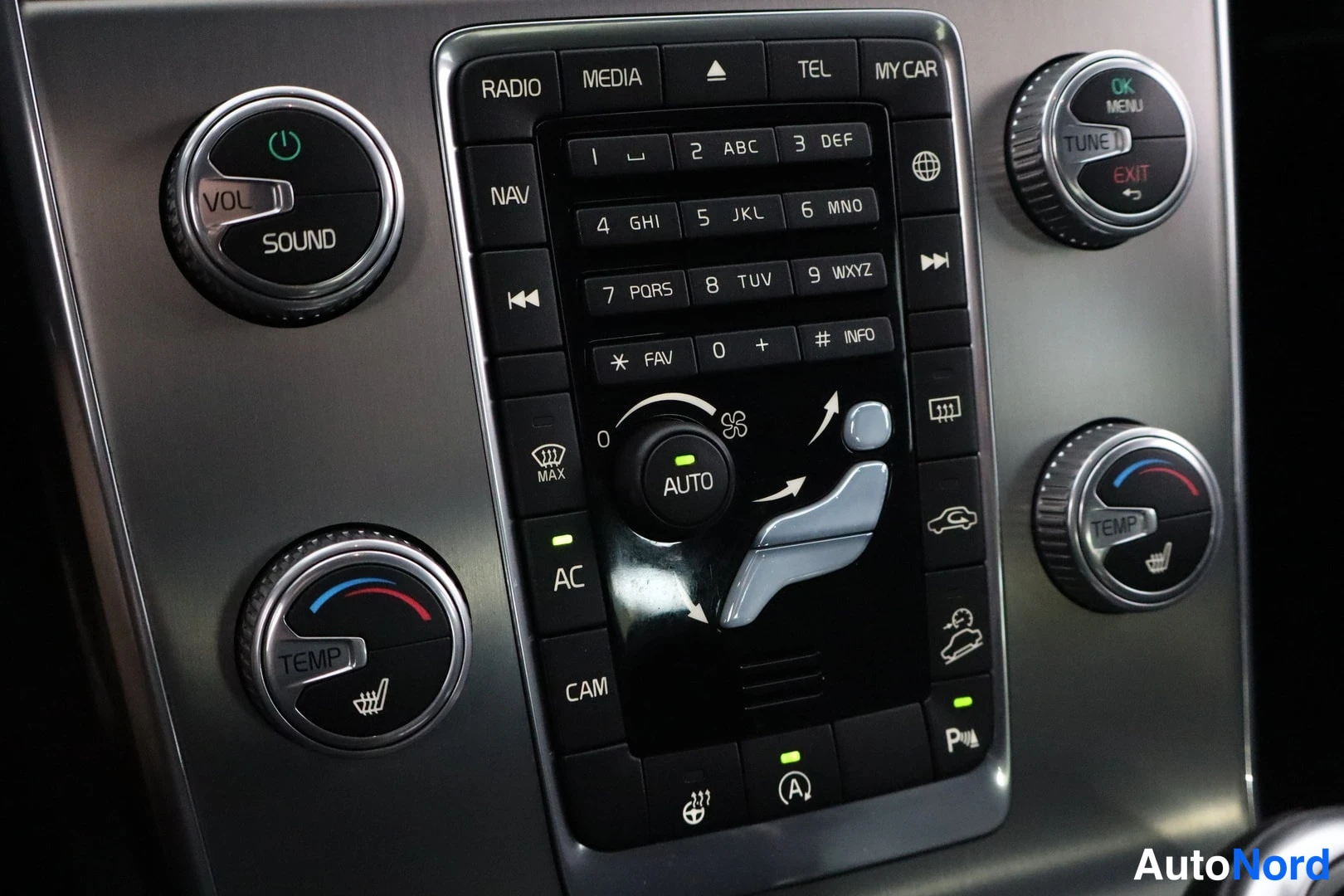 Muu: Keskikonsolin radio- ja ilmastointipaneeli, jossa näkyvät näppäimet RADIO, MEDIA, TEL, NAV, AC, CAM ja AUTO-painike.