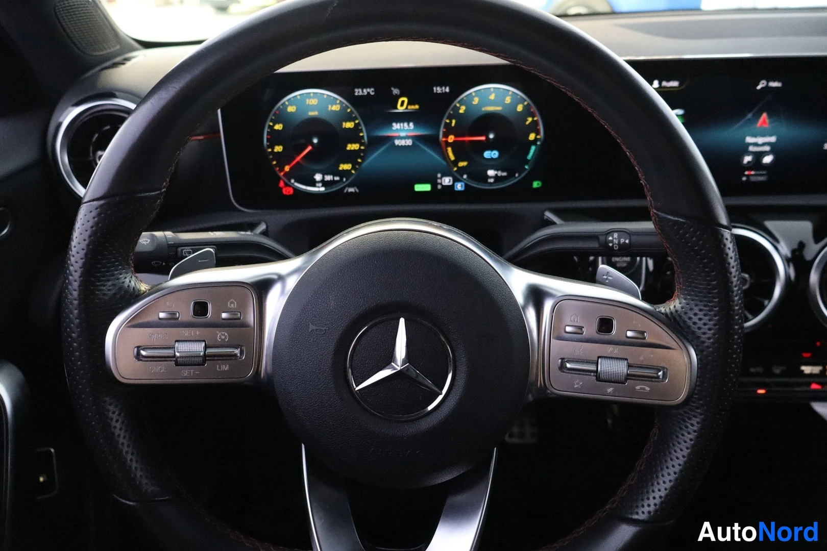 Etuistuimet: Sisäkuva: nahkaverhoiltu monitoimiohjauspyörä Mercedes-tunnuksella. Takana on digitaalinen mittaristo ja keskellä osittain näkyvä kosketusnäyttö.