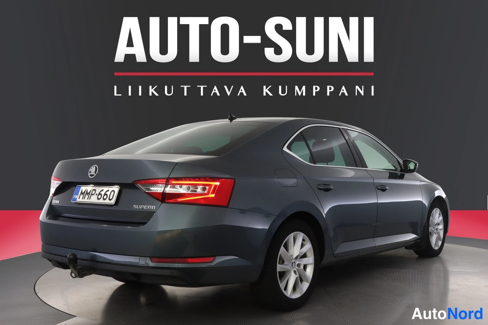 Takaviisto: Takaosa kolmivartalonäkymästä vasemmalta: takavalo, tavaratilan kansi, ŠKODA-merkki ja SUPERB-teksti, rekisteritunnus sekä vetokoukku takapuskurissa. Vasen kylk