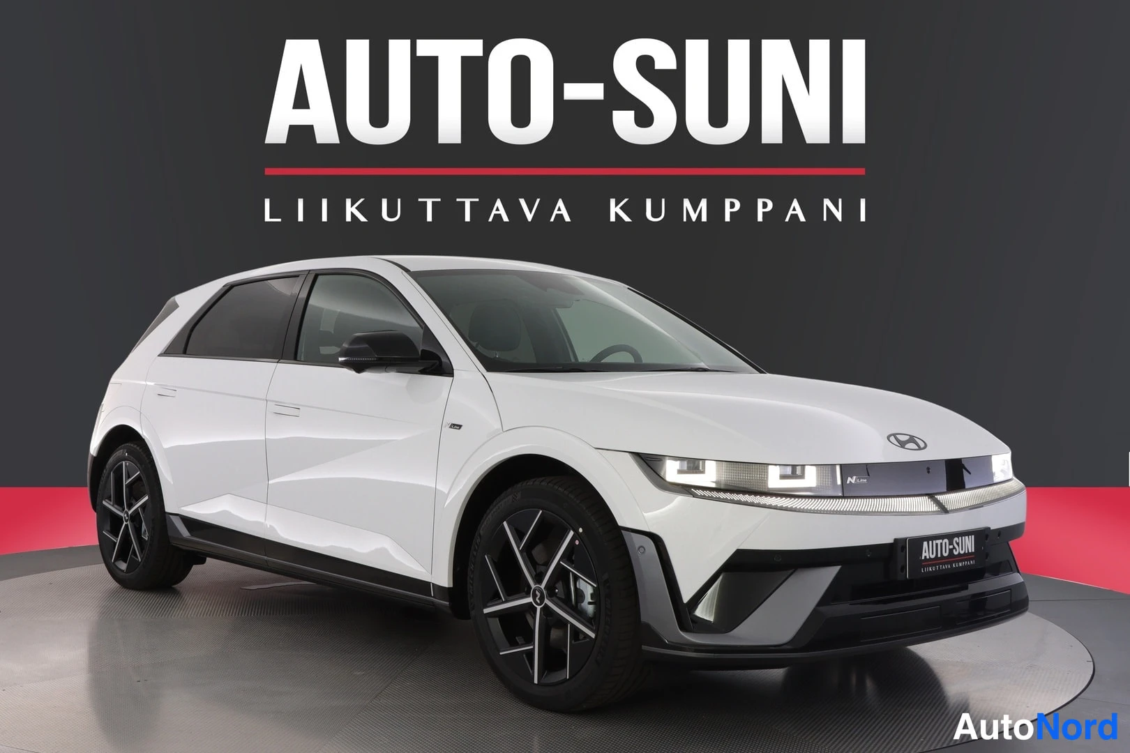 Etuviisto, nokka oikealle: Front three-quarter view of a white car in studio.