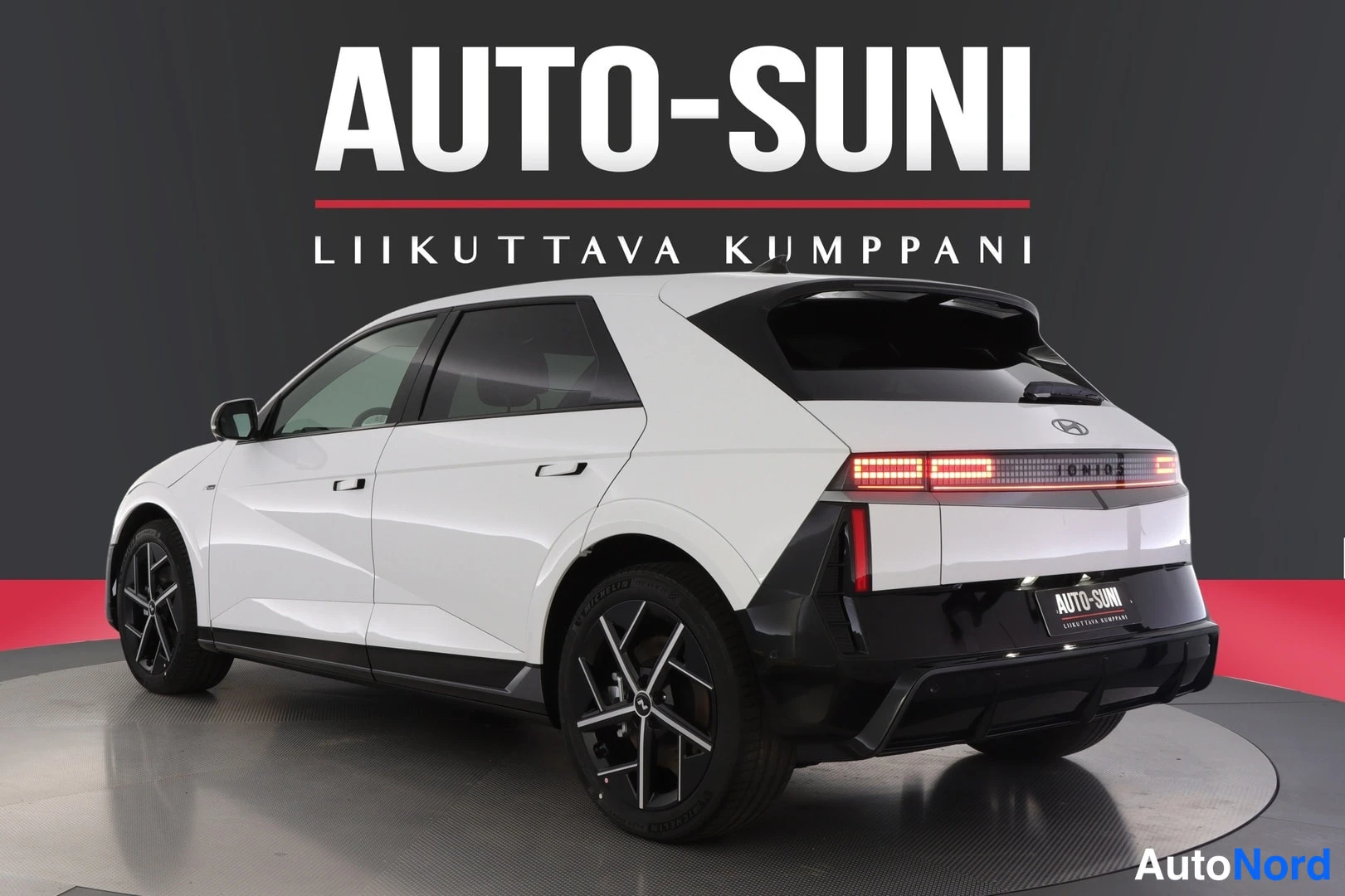 Takaviisto: Rear three-quarter view of a white car from opposite side.