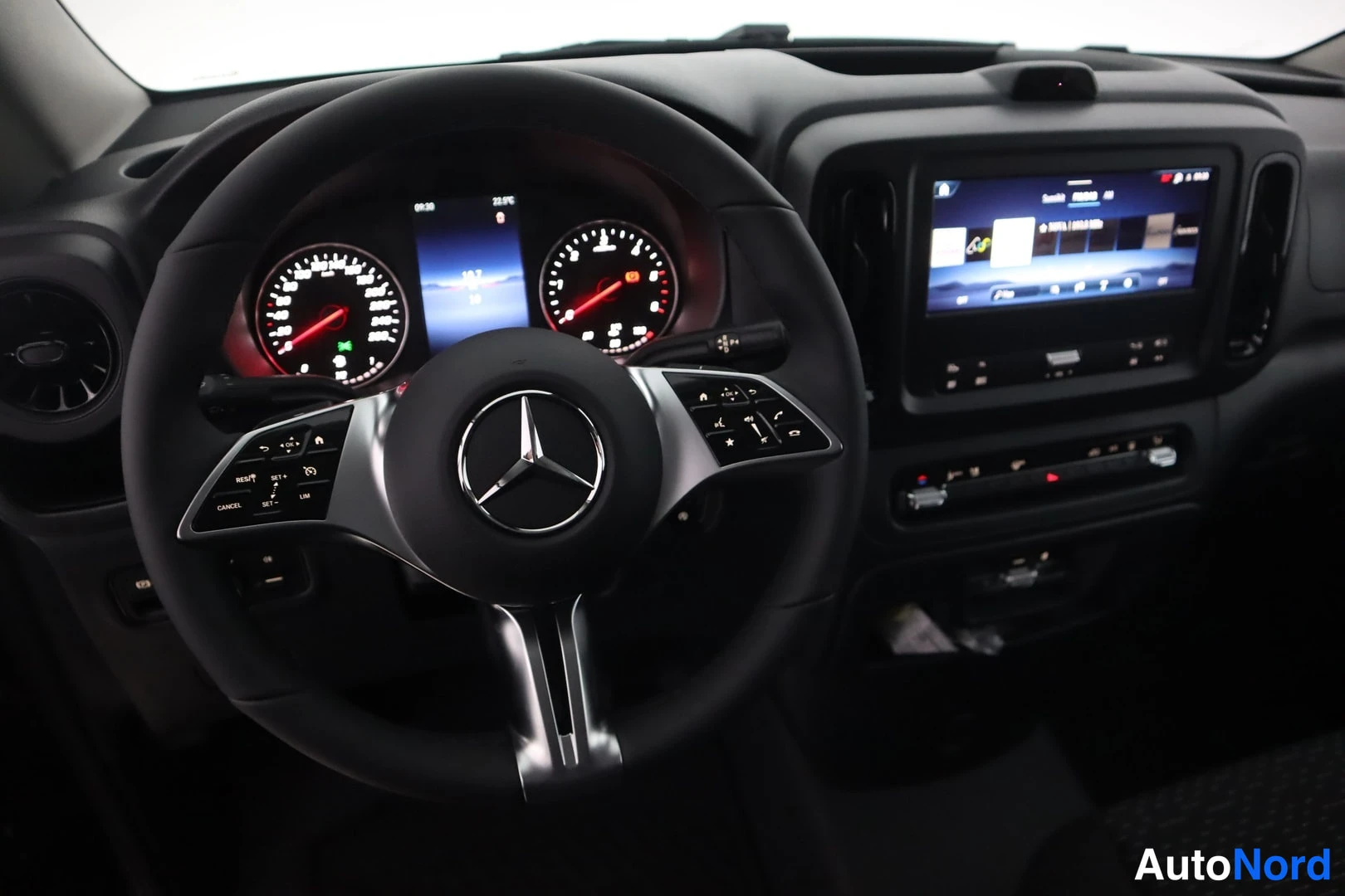 Etuistuimet: Ohjauspyörässä on Mercedes-Benz logo ja multifunktio-ohjaimet. Mittariston keskellä on digitaalinen näyttö, oikealla autotietoja. Oikealla näkyy kosketusnäyttö.