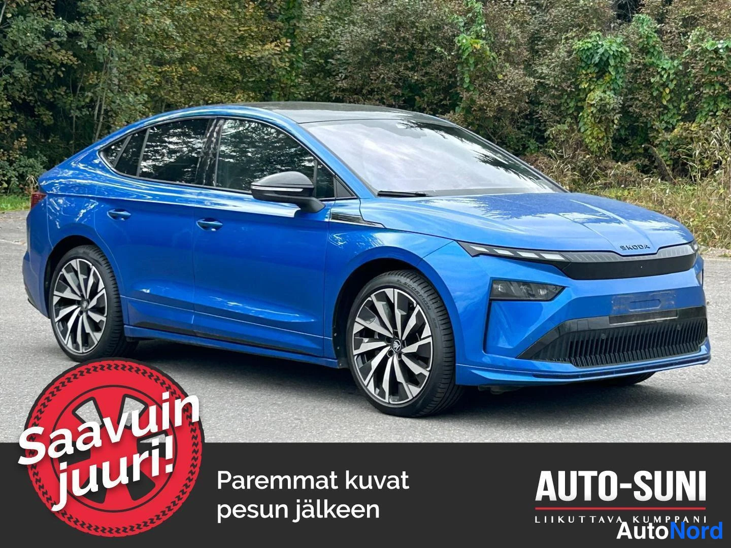 Etuviisto, nokka oikealle: Sininen Škoda Enyaq Coupé kuvattuna etuviistosta, keula oikealla; näkyvissä ŠKODA-tunnuksella varustettu etusäleikkö, ohuet ajovalot ja tummat ulkopeilit
