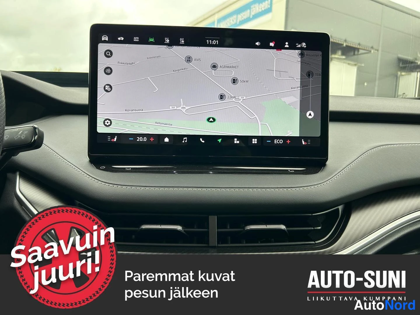 Ohjaamo: View of the center console touchscreen showing a navigation map interface. Visible below the screen are air vents with silver trim.