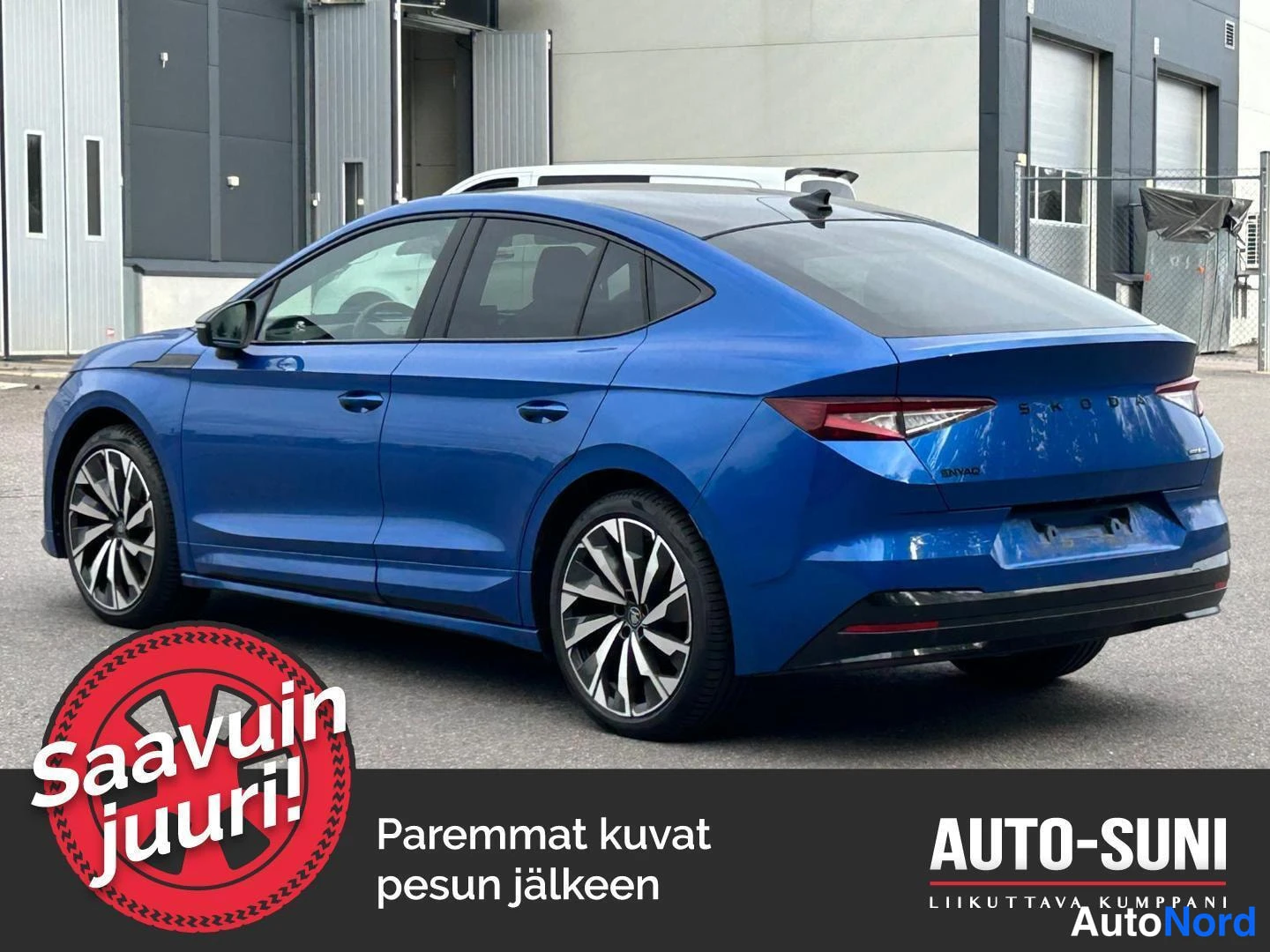 Takaviisto: Sininen Škoda Enyaq Coupé kuvattuna takaviistosta, takaosa oikealla; näkyvissä takaluukun ŠKODA-teksti, ENYAQ-teksti, takavalot ja tumma takapuskurin alaosa. Re