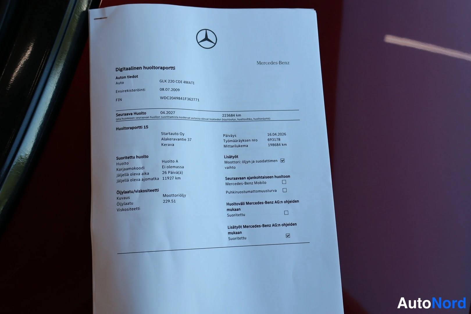 Yksityiskohta: Mercedes-Benzin digitaalinen huoltoraportti paperina: auton tiedot, huoltoraportti 15 ja suoritetut huollot näkyvissä.