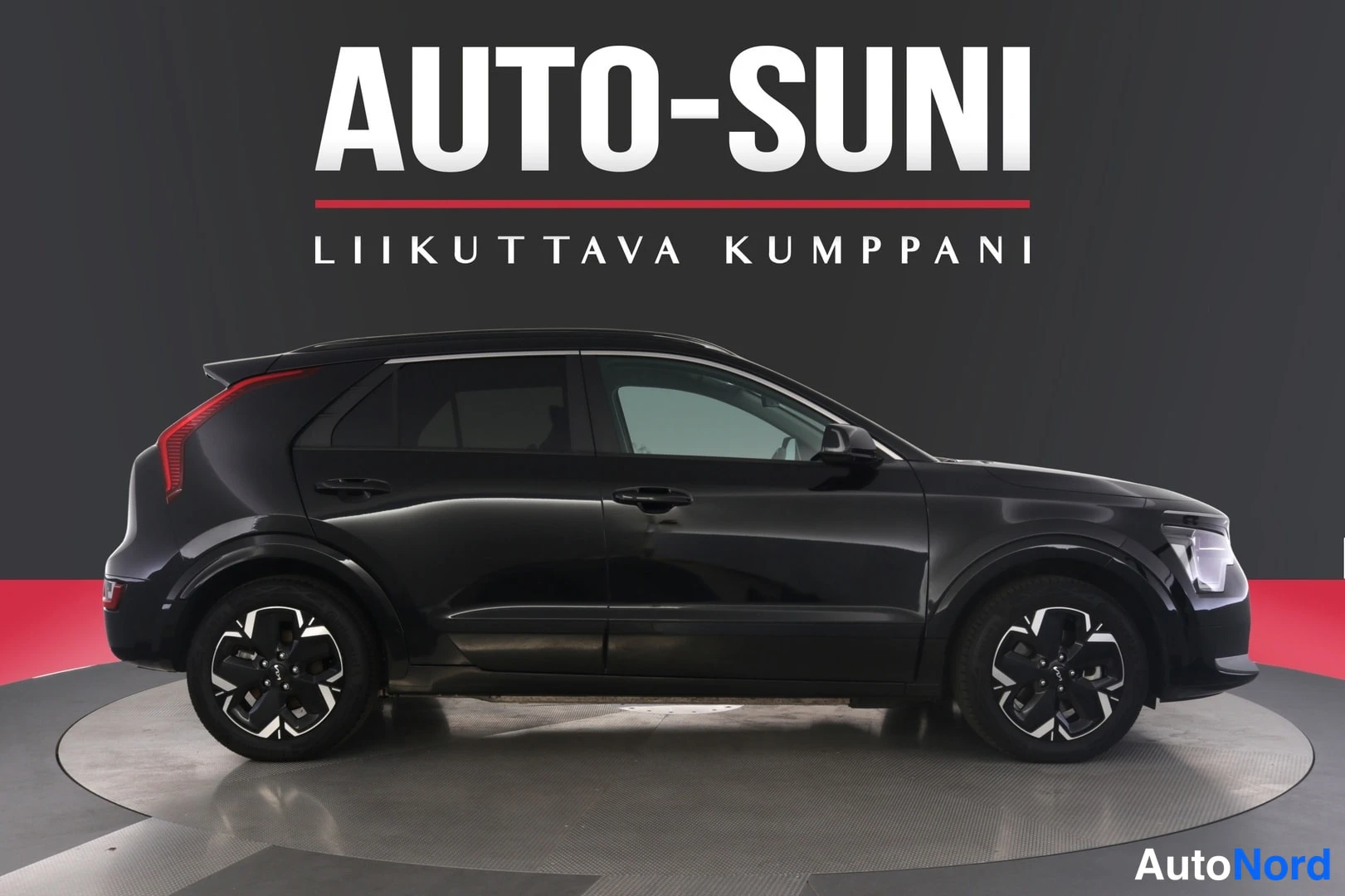 Sivulta: Musta Kia Niro sivuprofiilissa, keula kuvan oikeassa reunassa.