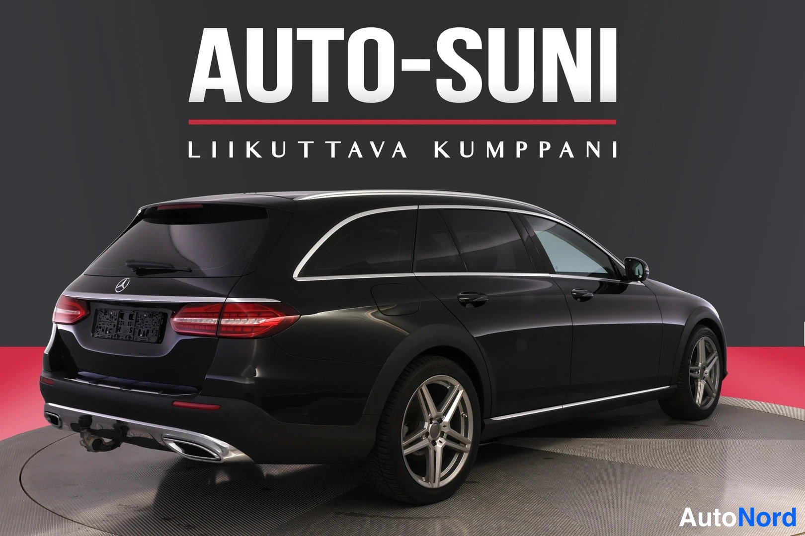 Takaviisto: Musta farmariauto takaviistosta kuvattuna studiotaustassa, punaiset takavalot ja hopeiset vanteet näkyvät.