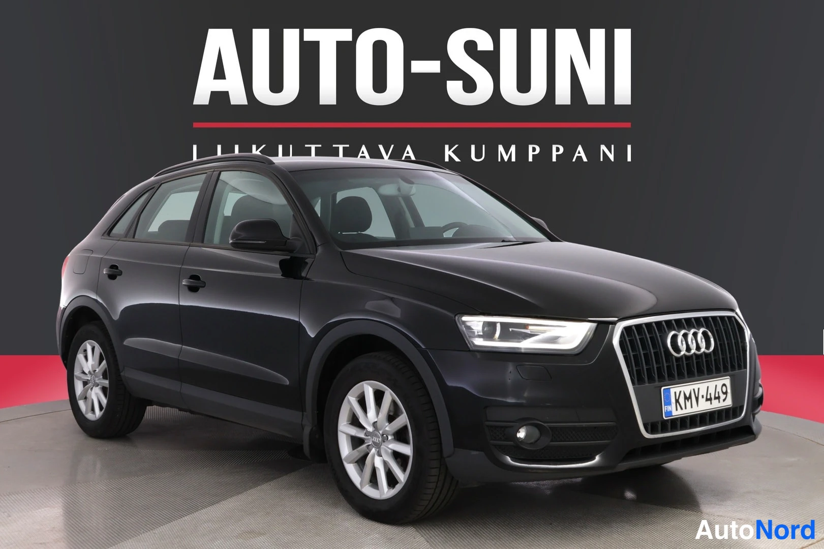 Etuviisto, nokka oikealle: Musta Audi Q3 -maast_auto etuosoalta oikeaan alakulmaan kääntyneenä studiotaustaa vasten, rekisteritunnus, valkoiset vanteet ja AUTO-SUNI mainosteksti ta