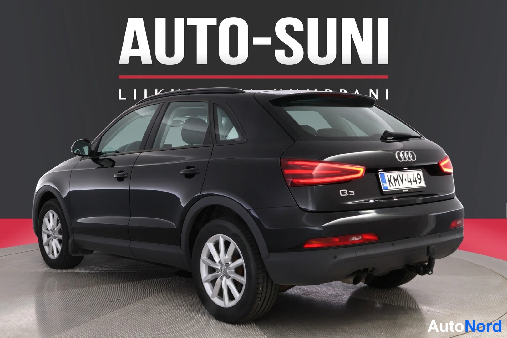 Takaviisto: Musta Audi Q3 -maast_auto etuosoalta oikeaan alakulmaan kääntyneenä studiotaustaa vasten, rekisteritunnus, valkoiset vanteet ja AUTO-SUNI mainosteksti taustalla