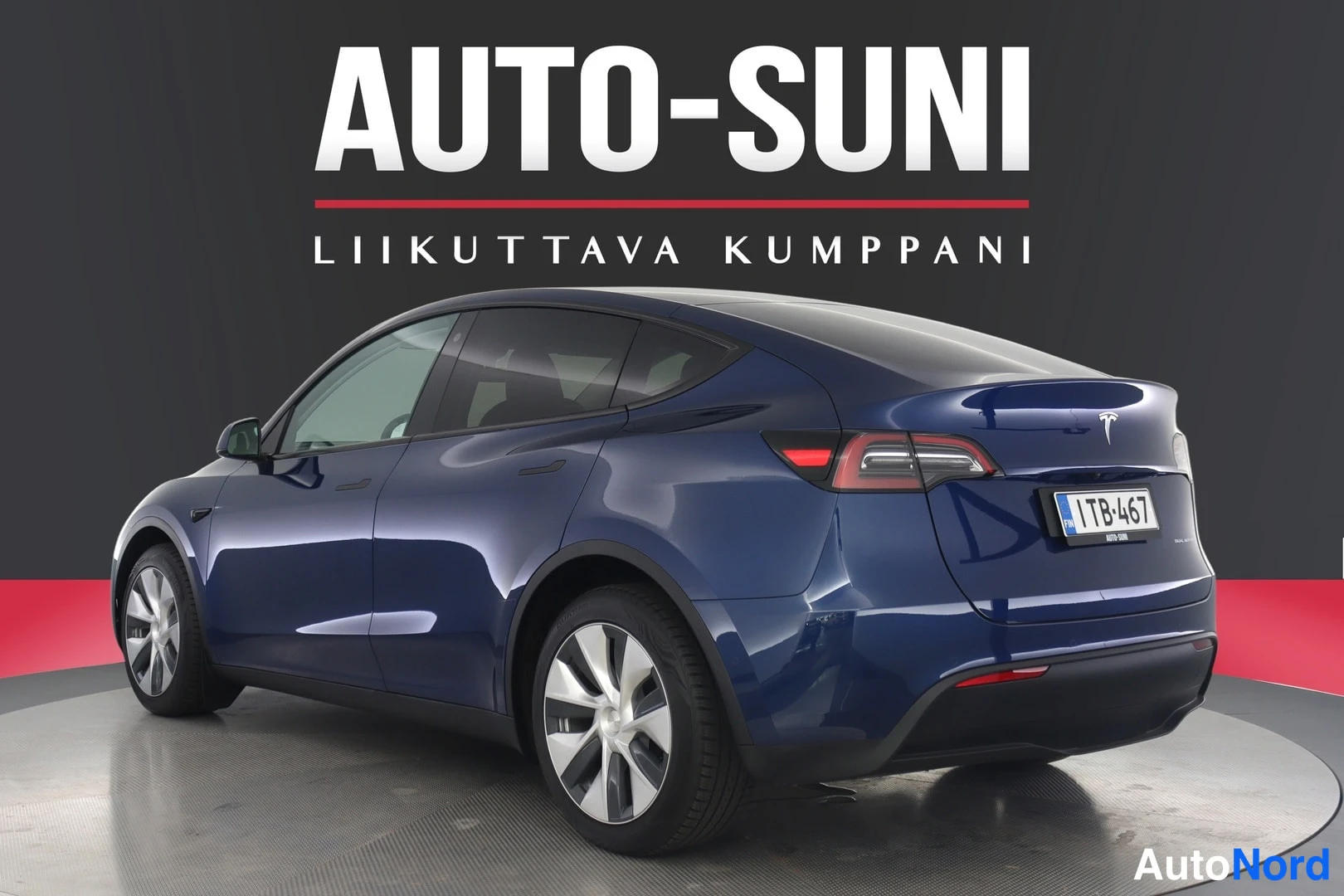 Takaviisto: Tummansininen Tesla Model Y takaa oikealta kulmasta kuvattuna, rekisterikilpi.