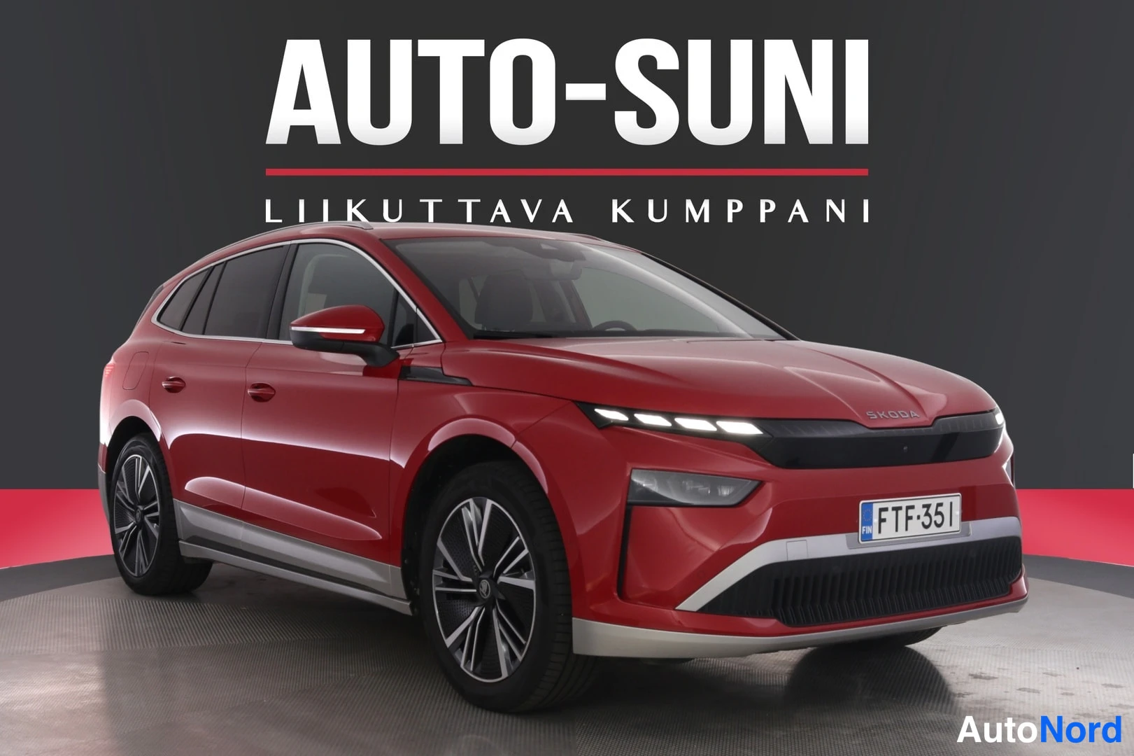 Etuviisto, nokka oikealle: Punainen Skoda Enyaq -maasturii kolmivartaista edestä oikealta kuvattuna, rekisterikilpi.