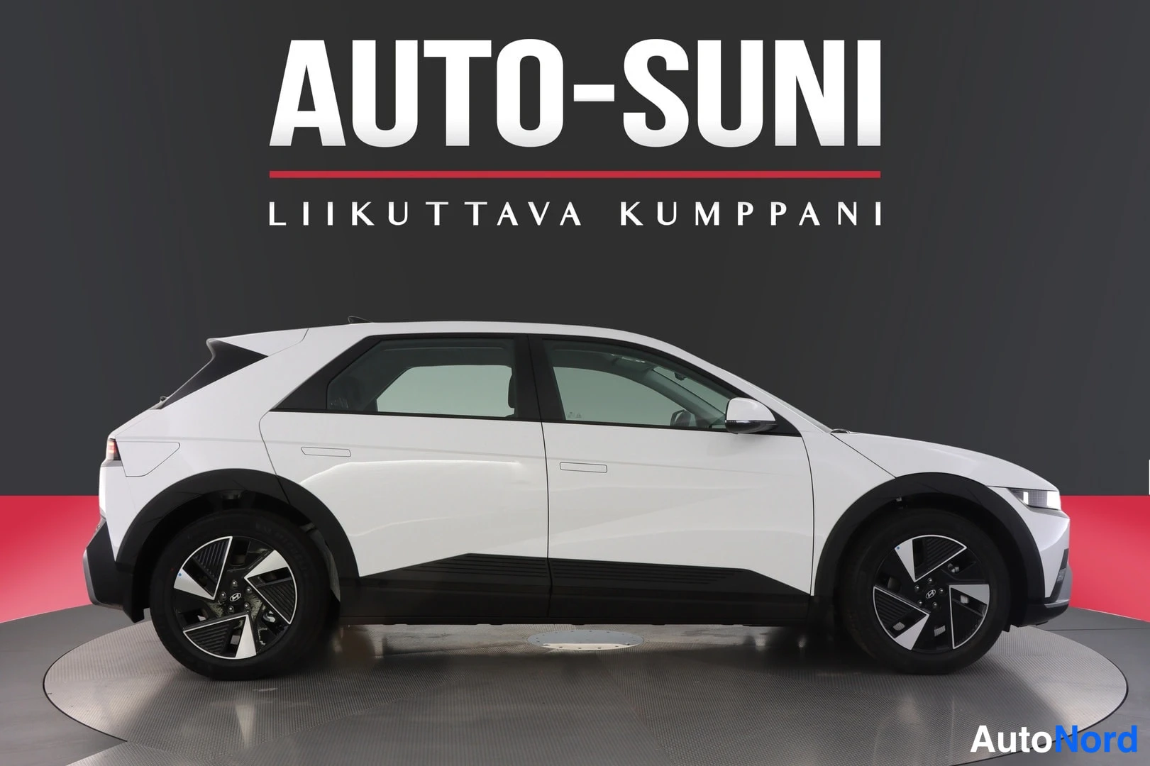 Sivulta: Valkoisen Hyundai IONIQ 5:n oikea kylki tässä profiilissa studiotaustaa vasten.