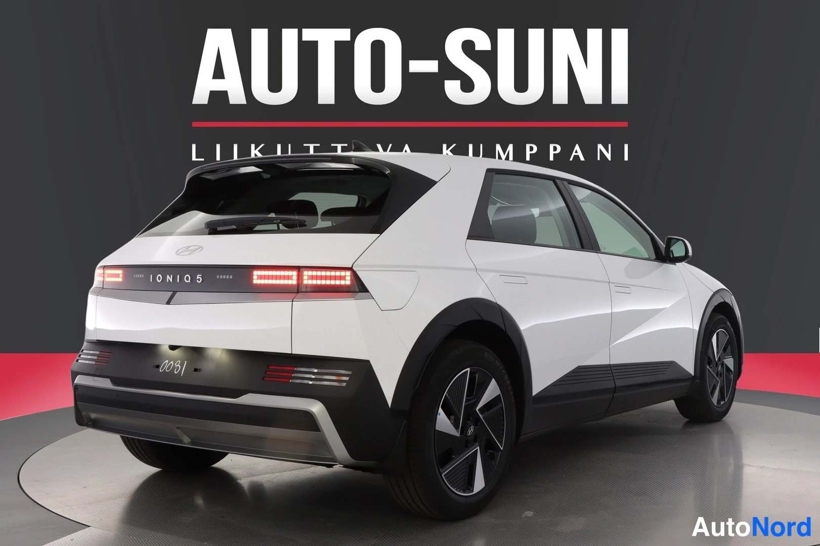 Takaviisto: Valkoisen Hyundai IONIQ 5:n takaosa ja vasen kylki viistosti, IONIQ 5 -teksti takavalossa ja Rekko-taustakuva.