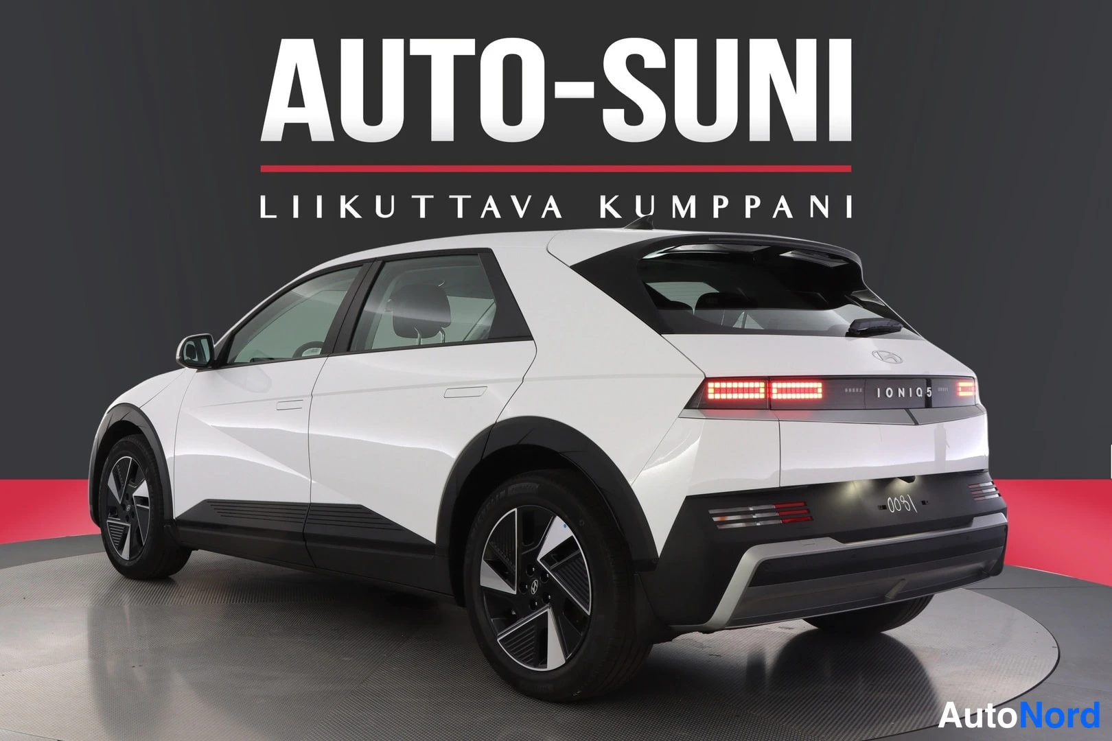 Takaviisto: Valkoisen Hyundai IONIQ 5:n takaosa ja vasen kylki viistosti toisesta suunnasta, takavalo ja IONIQ 5 -teksti näkyvissä.