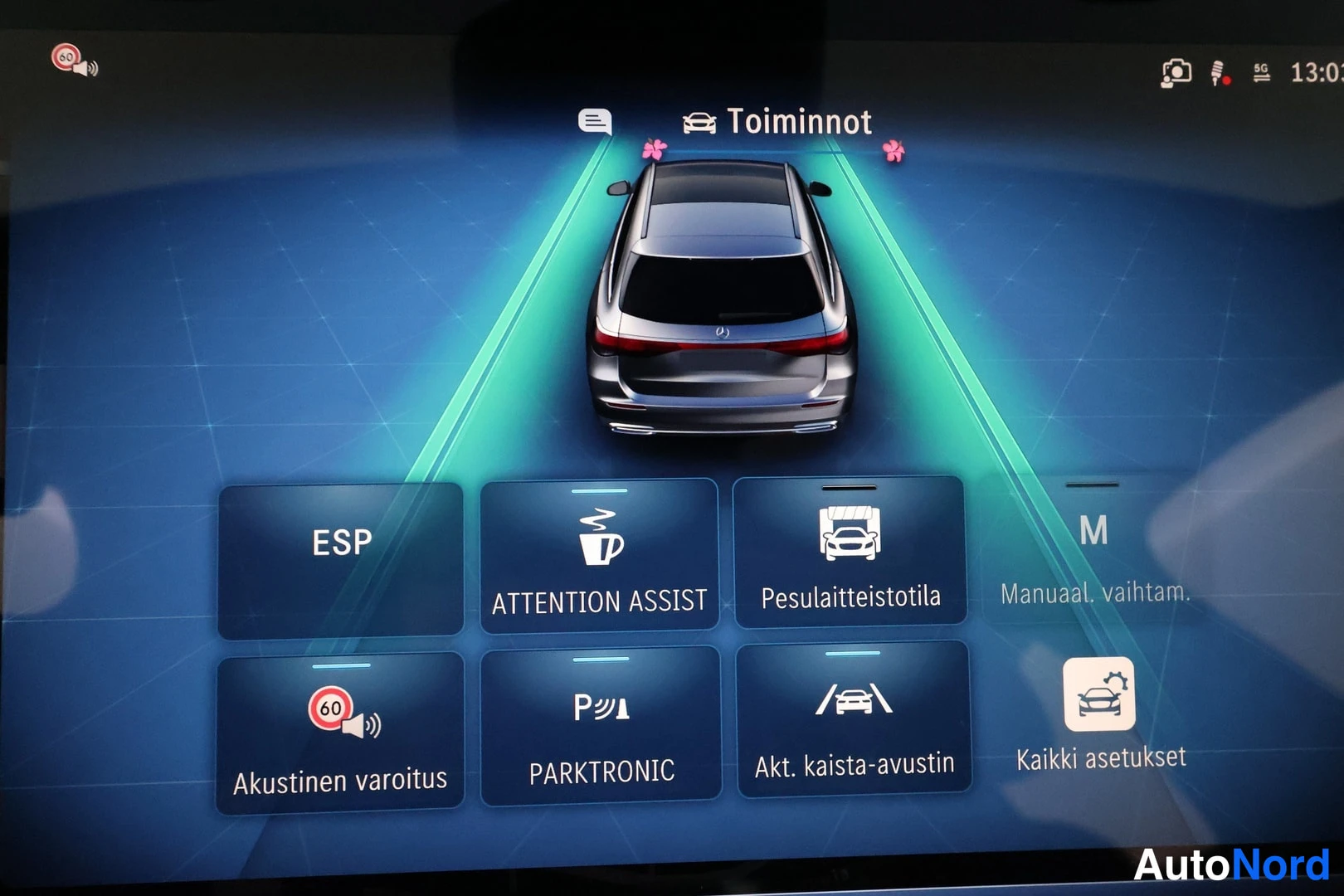Muu: Sisätiloissa otettu kuva auton infotainment-näytön kuljettajaa avustavista toiminnoista.