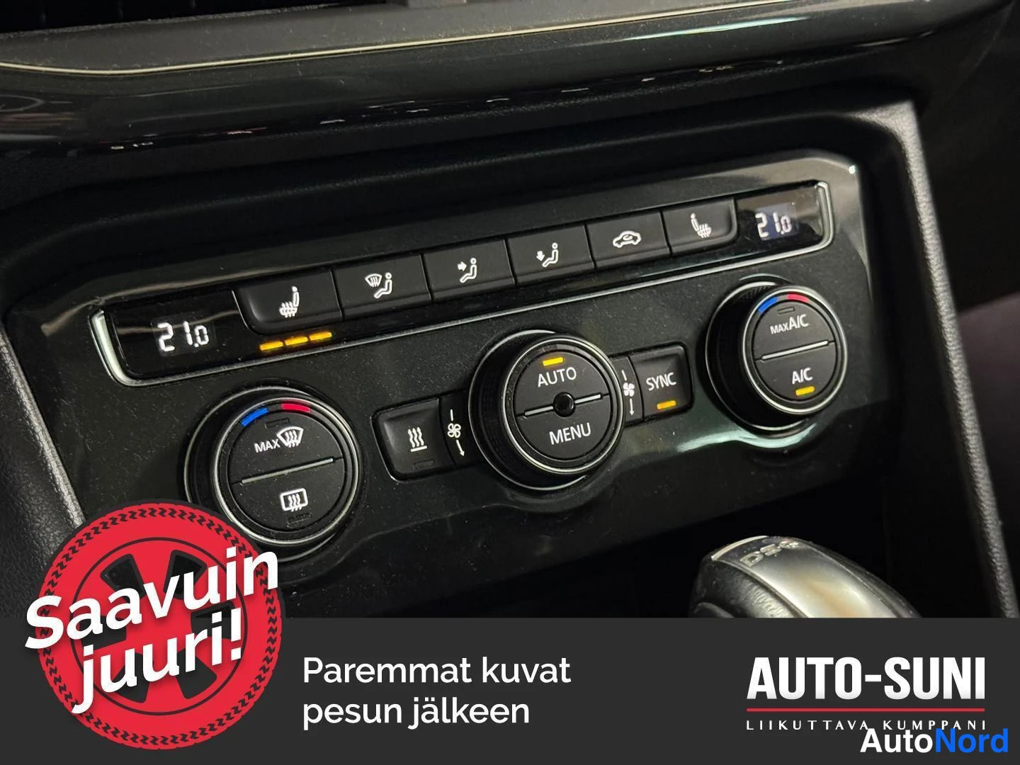 Yksityiskohta: Kojetason ilmastointipaneeli näytöillä 21.0; nappien AUTO, A/C, MAX A/C, SYNC ja MENU sekä lämmitinmerkit.