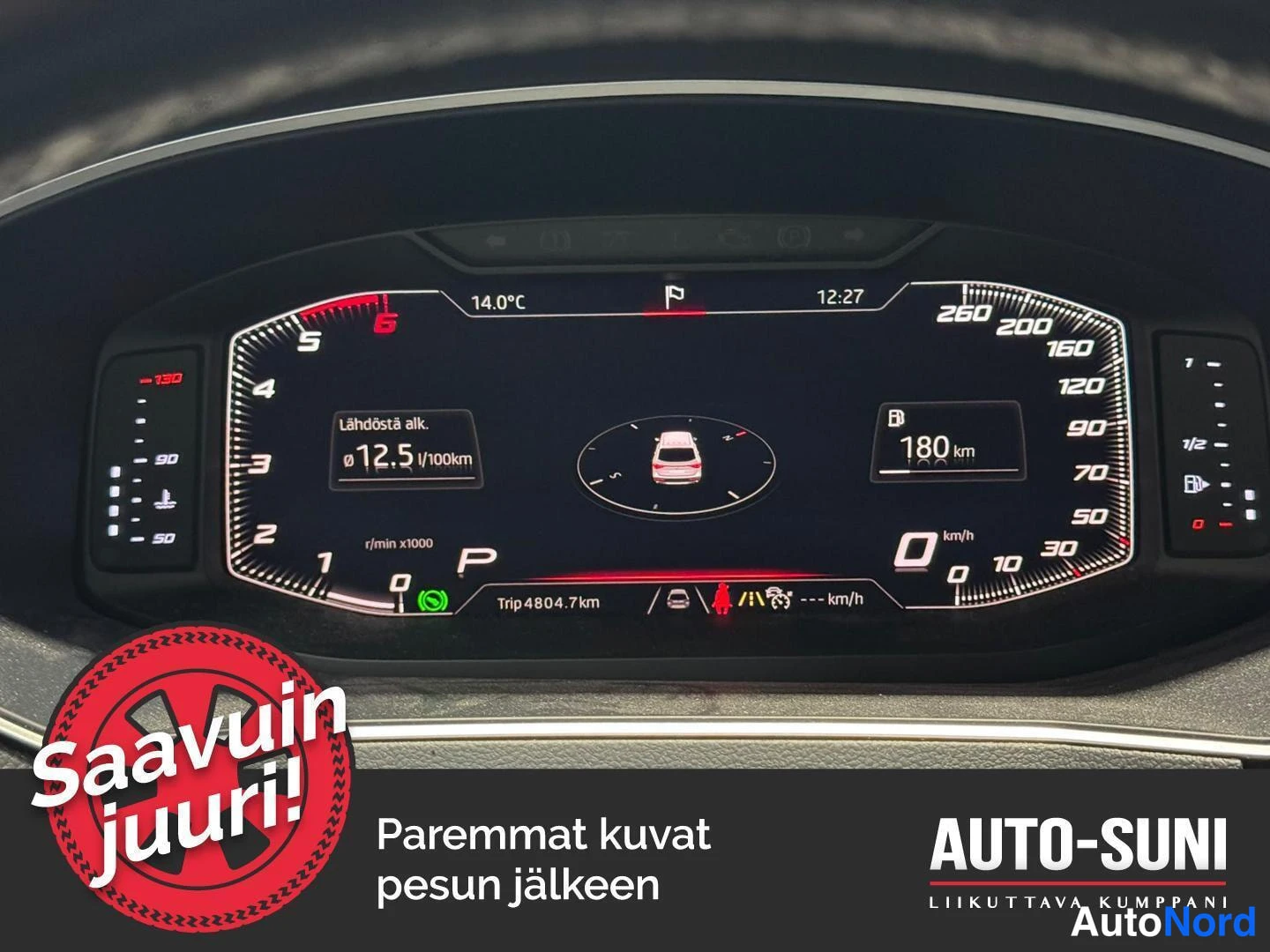 Yksityiskohta: Ajon aikana otettu kuuma 10-käyttäjän sisäkuva ratin ja etupaneelin välissä, jossa näkyy tumma kilpi ja ohjauspyörän muotoilu. Kuva on ylhäältäpäin otettu.