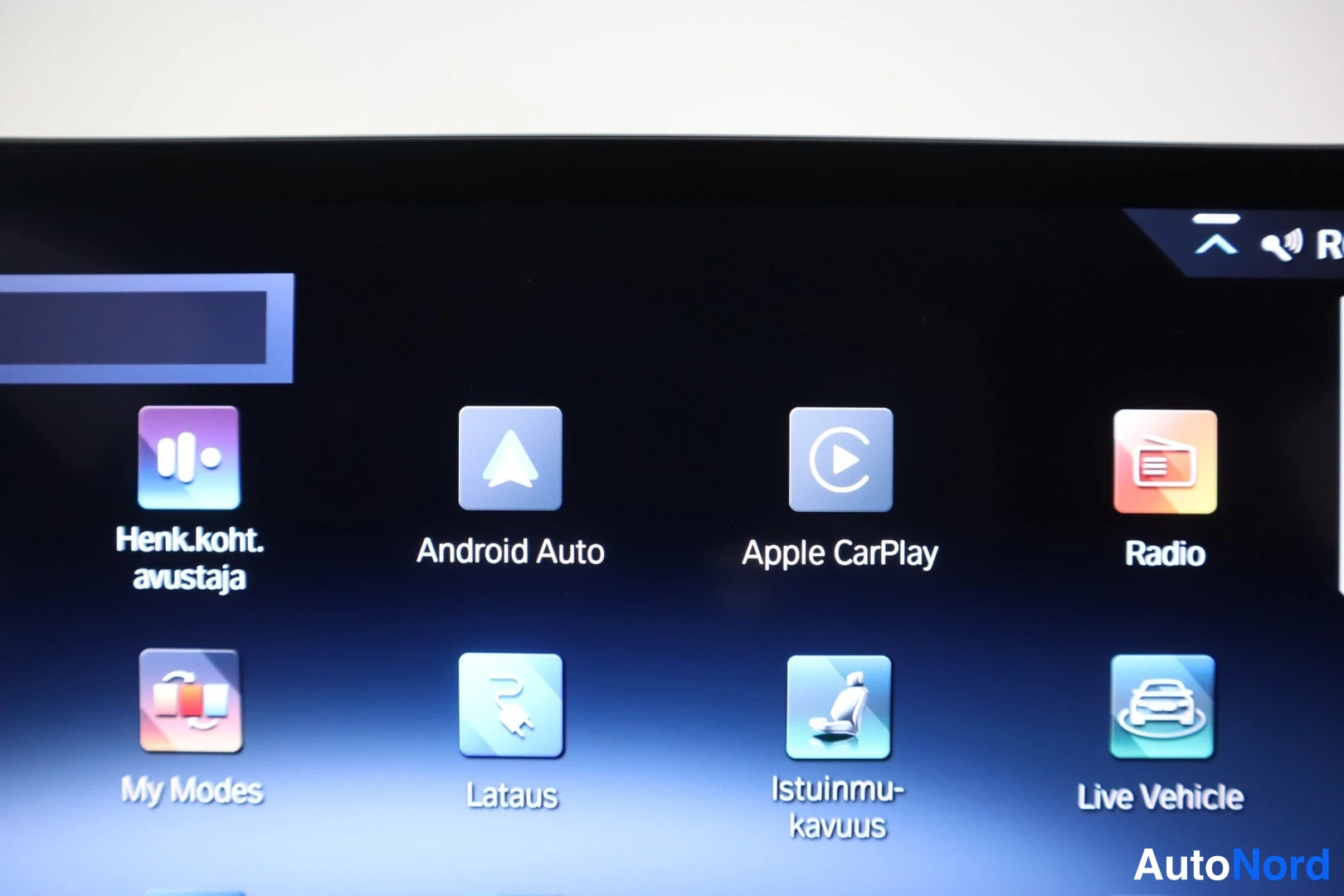 Muu: Infotainment-näytön sovellusvalikko, jossa näkyvät Android Auto, Apple CarPlay, Radio, Henk.koht. avustaja, My Modes, Lataus, Istuinmukavuus ja Live Vehicle.