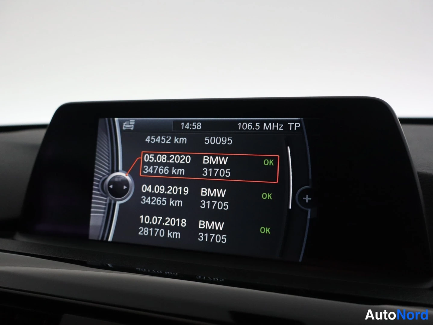 Edestä: Kojelaudan näyttö Service history -näkymässä: huolto 05.08.2020 (34766 km, BMW 31705, OK) korostettuna, aiemmin 04.09.2019 (34265 km) ja 10.07.2018 (28170 km),