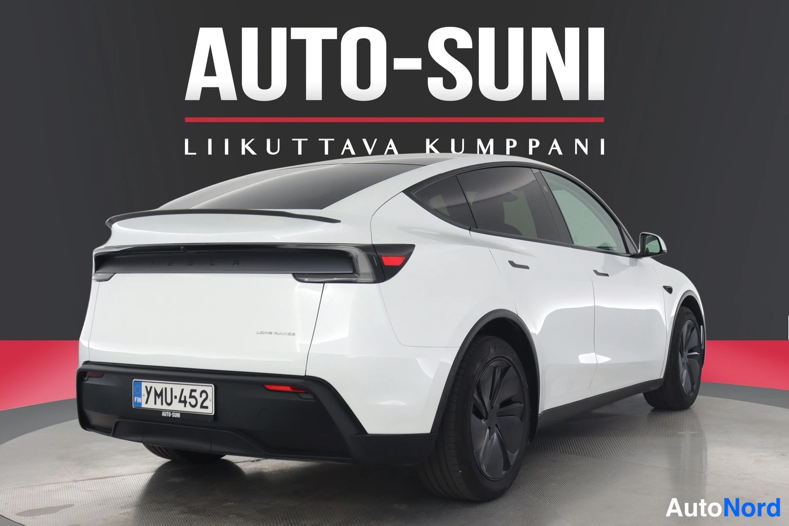 Takaviisto: Valkoisen Tesla Model Y:n takaosaa ja vasenta kylkeä, takapuskun ja takavalojen näkyessä.