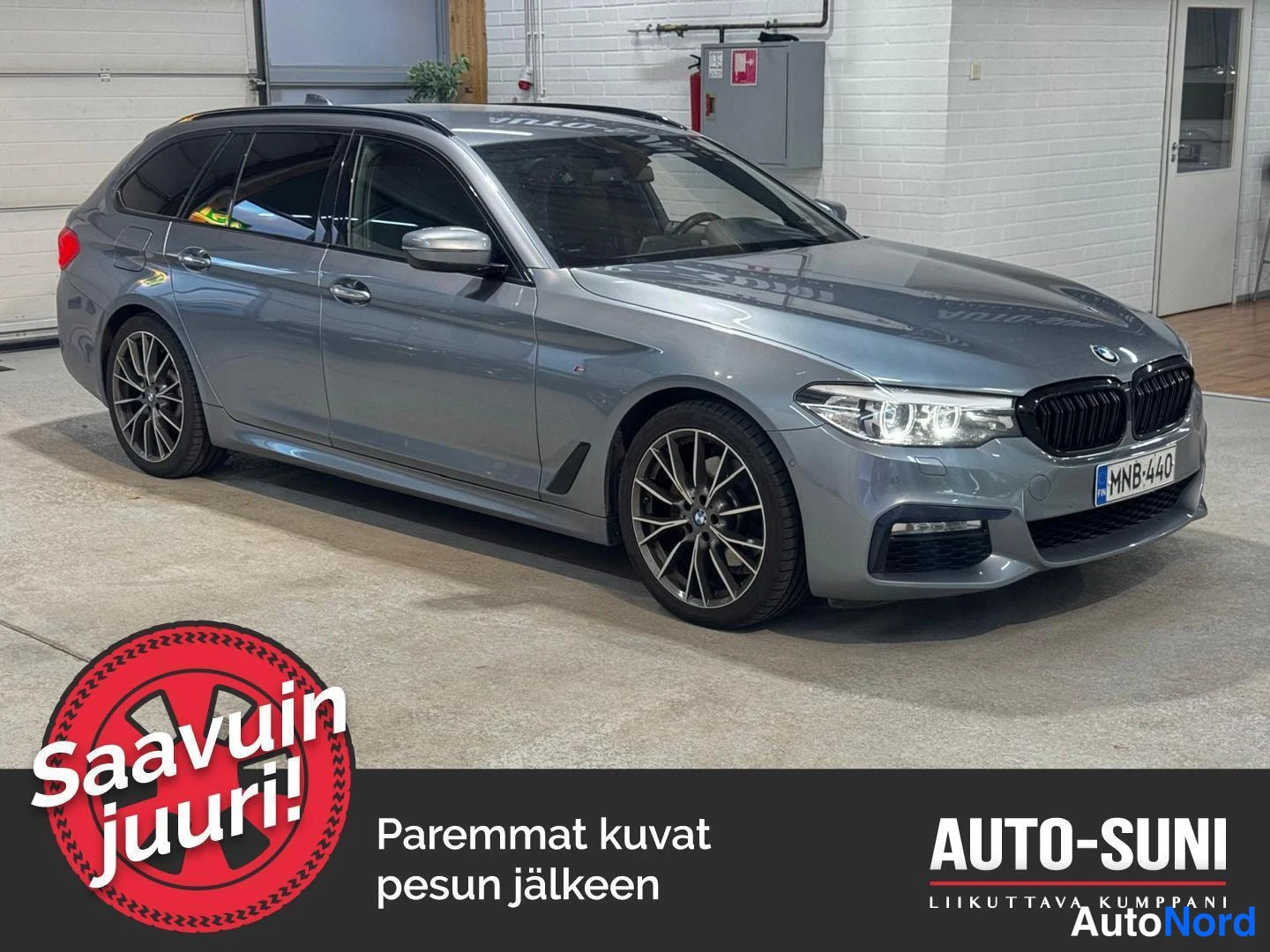 Etuviisto, nokka oikealle: Hopeanharmaa BMW 5-sarjan farmari kuvattuna kolmasosa-estäproof ylävasemmalta, etusäleikkö ja rekisterikilpi näkyvät oikealla.