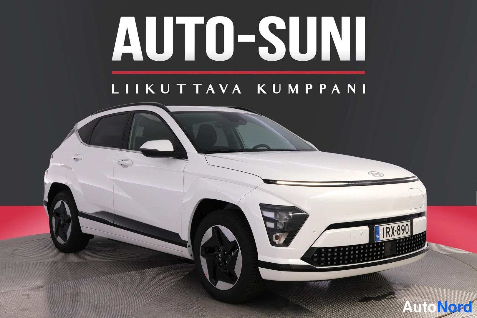 Etuviisto, nokka oikealle: Valkoinen Hyundai Kona Electric etu Kolmessa neljännesnäkymässä studiossa, rekisterikilpi.