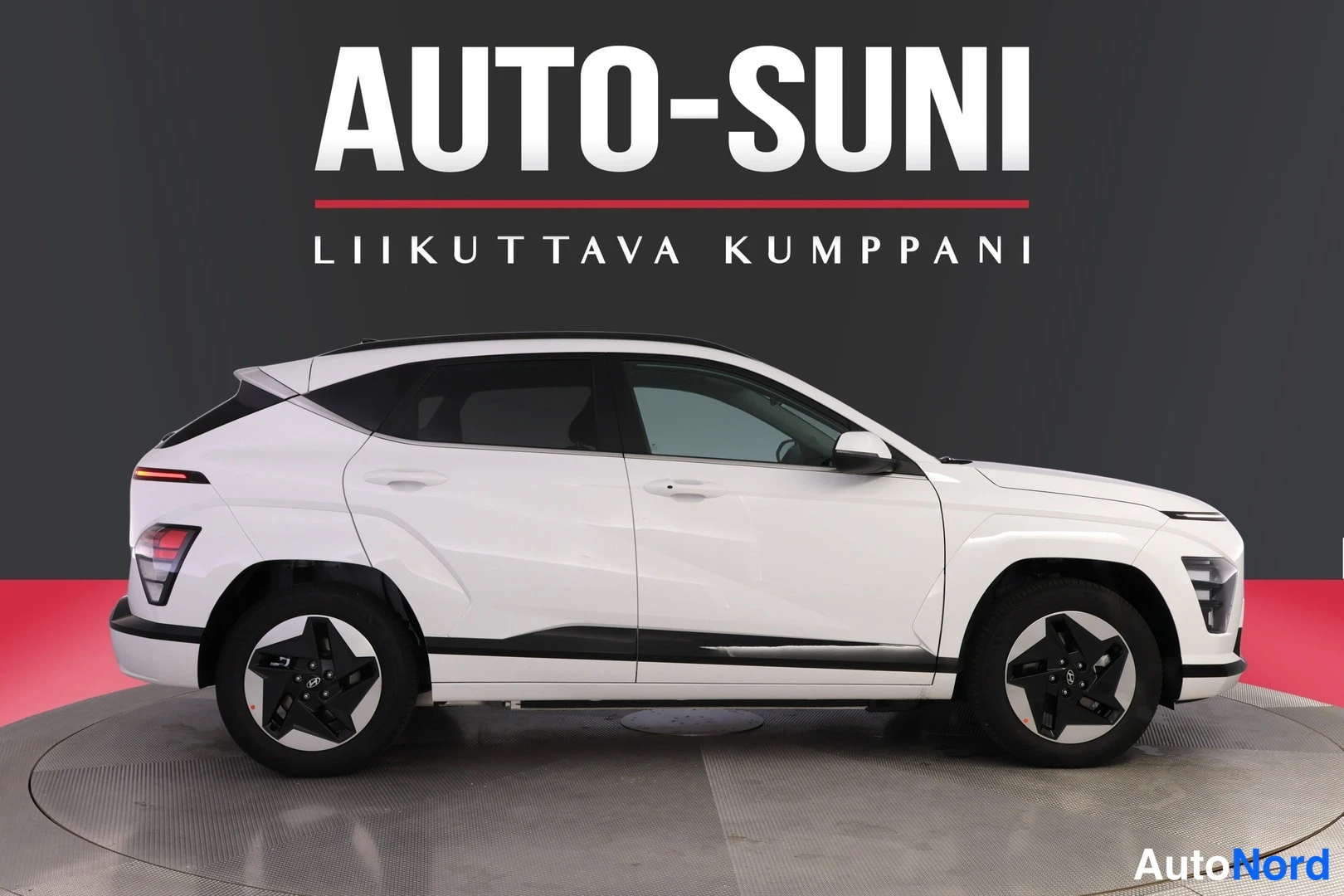 Sivulta: Valkoisen Hyundai Kona Electricin sivunäkymä studiossa, mustat korostukset ovien alla.