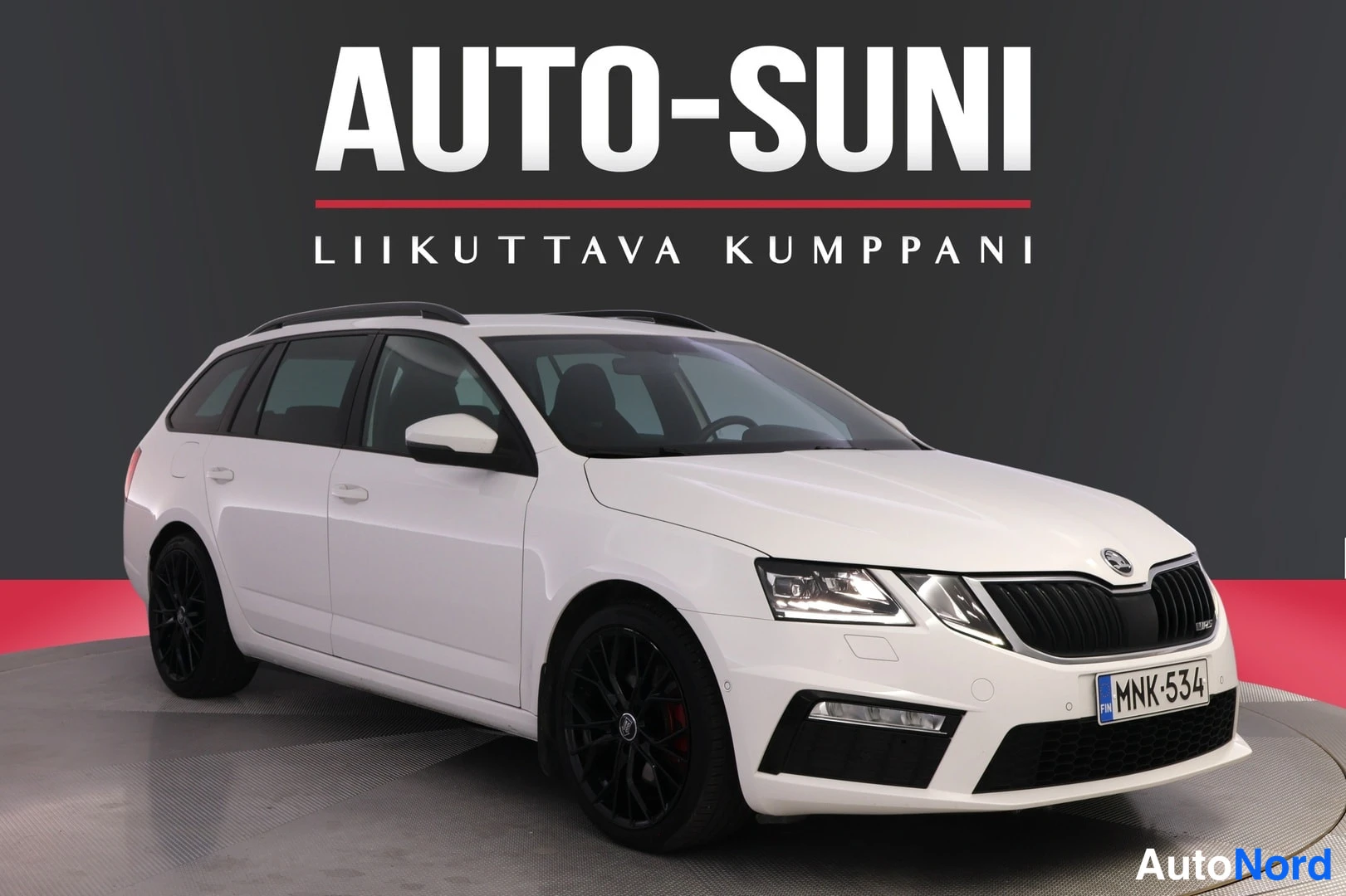 Etuviisto, nokka oikealle: Valkoinen Skoda Octavia Combi -farmari Auto-Suni-studioa taustana, etukulmakuva oikealta, tummat vanteet ja kattokaiteet
