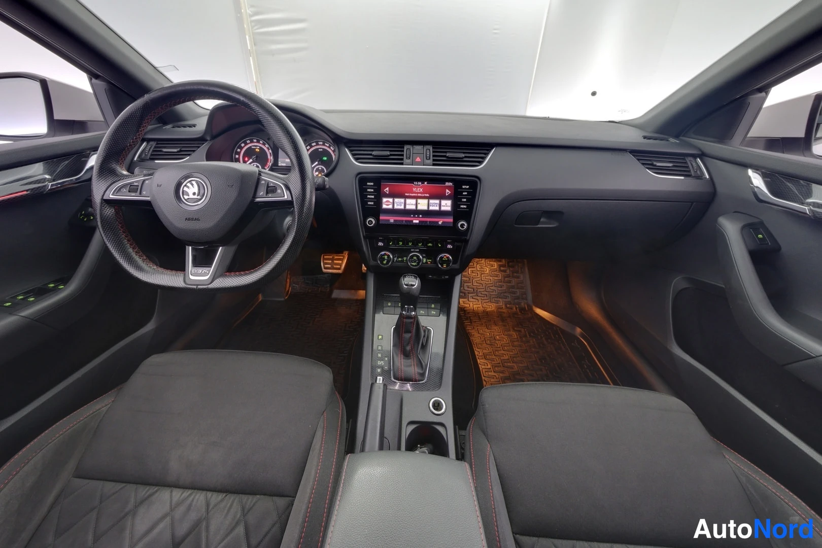 Muu: Auton ohjaamo etupenkiltä: Skoda-ohjauspyörä, kosketusnäytöllinen radiopaneeli ja automaattivaihteen valitsin.