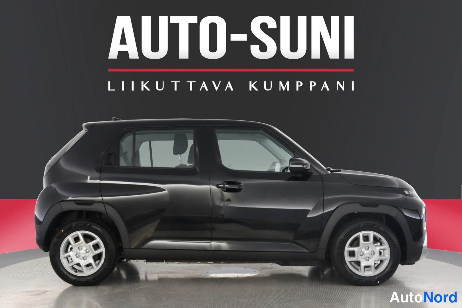 Sivulta: Musta Hyundai Inster sivulta kuvattuna studiotaustassa.