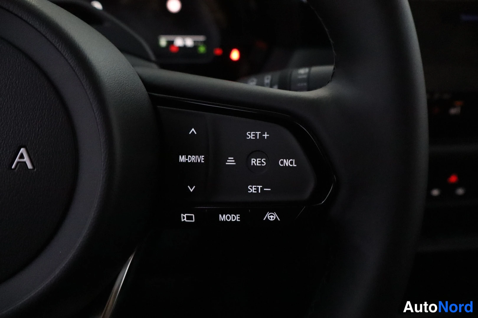 Yksityiskohta: Ohjauspyörän oikea painikepöytä: MI-DRIVE, SET+, RES, CNCL, SET−, MODE ja adjunktiivisen ajon merkit.