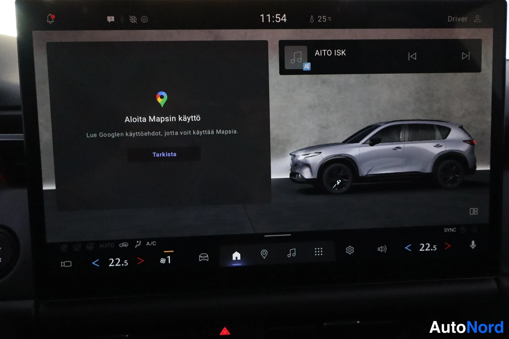 Muu: Mazdan infotainment-näyttö, jossa aloitetaan Google Mapsin käyttöä ja toistetaan radiota (AITO ISK). Näytön alareunassa ilmastoinnin säätimet, lämpötila 22,5 as