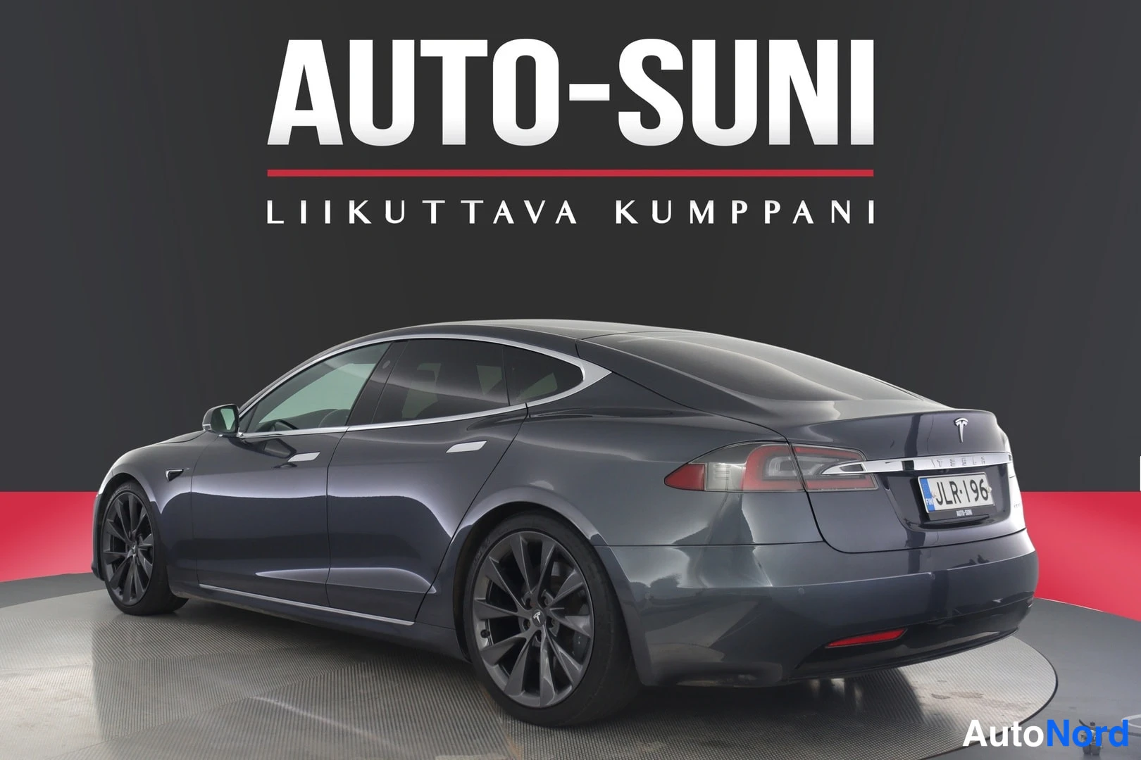 Takaviisto: Tummanharmaa Tesla Model S takaosa kolmannelta kulmalta vasemmalta, perä ja kylki näkyvissä, rekisterikilpi.