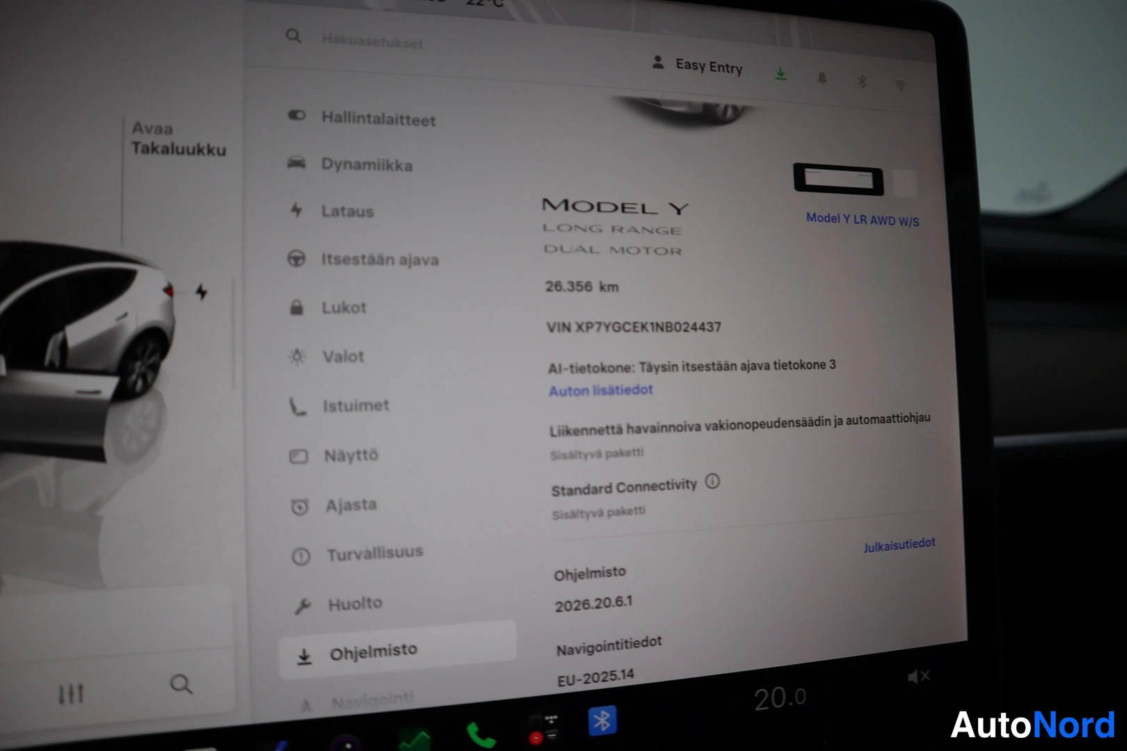 Yksityiskohta: Tesla Model Y - auton kosketusnäytön Ohjelmisto-näkymä, jossa luettavissa mallitiedot MODEL Y LONG RANGE DUAL MOTOR, VIN ja ajoneuvon lisätiedot.