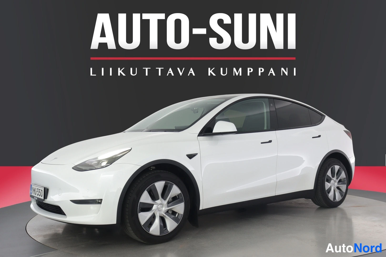 Etuviisto, nokka vasemmalle: Valkoinen Tesla Model Y etuviistosta vasemmalta eteenpäin kuvattuna。