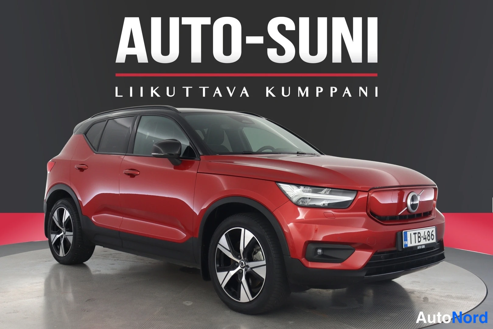 Etuviisto, nokka oikealle: Punainen Volvo XC40 etukulmasta oikealta, musta katto ja mustat korikulmat, rekisterikilpi