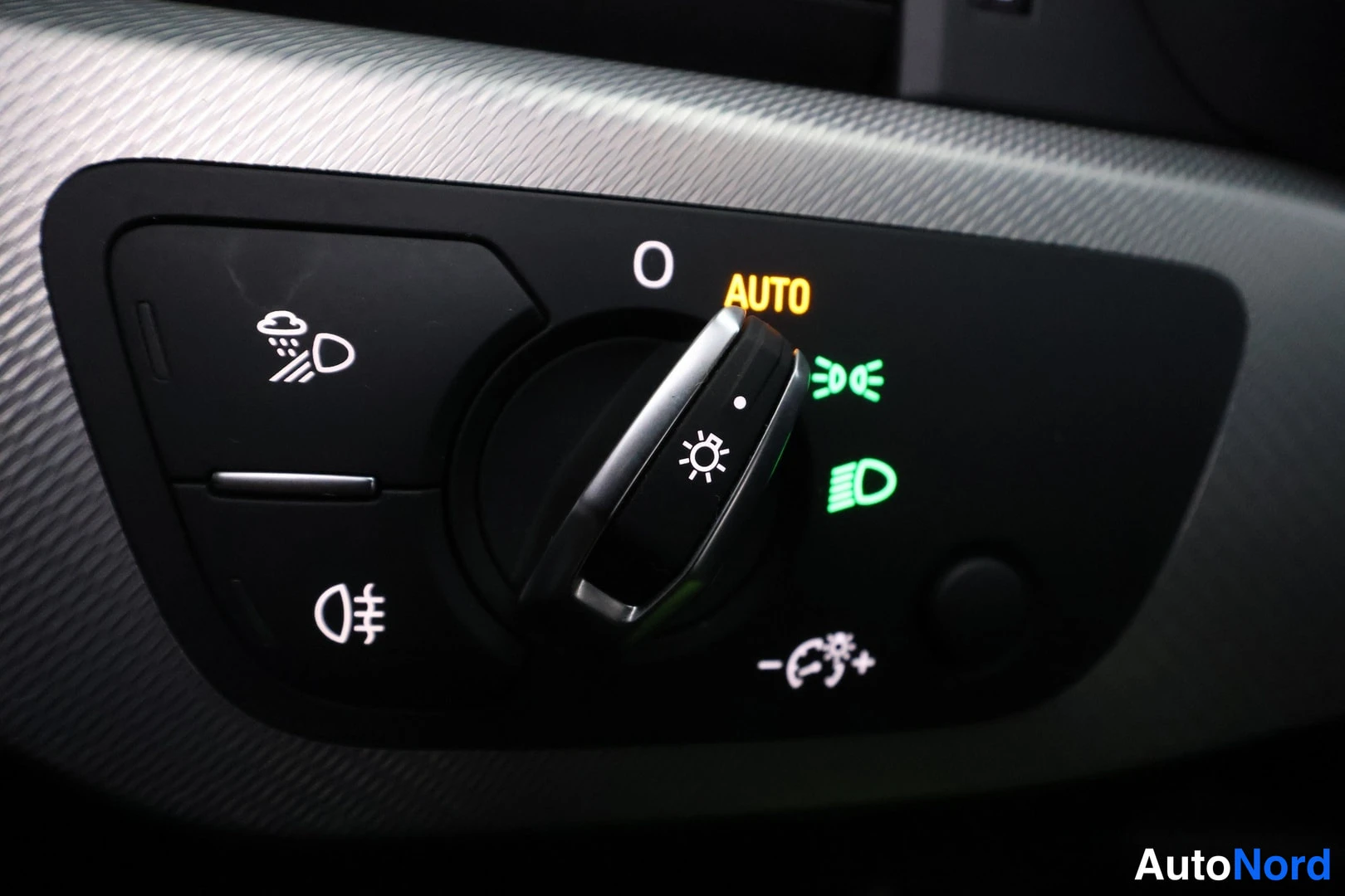 Etuviisto, nokka vasemmalle: Valokytkimien säädin AUTO-asennossa, ympäristövalot ja sumuvalot kuvakkeina merkkivaloja syttyneinä.