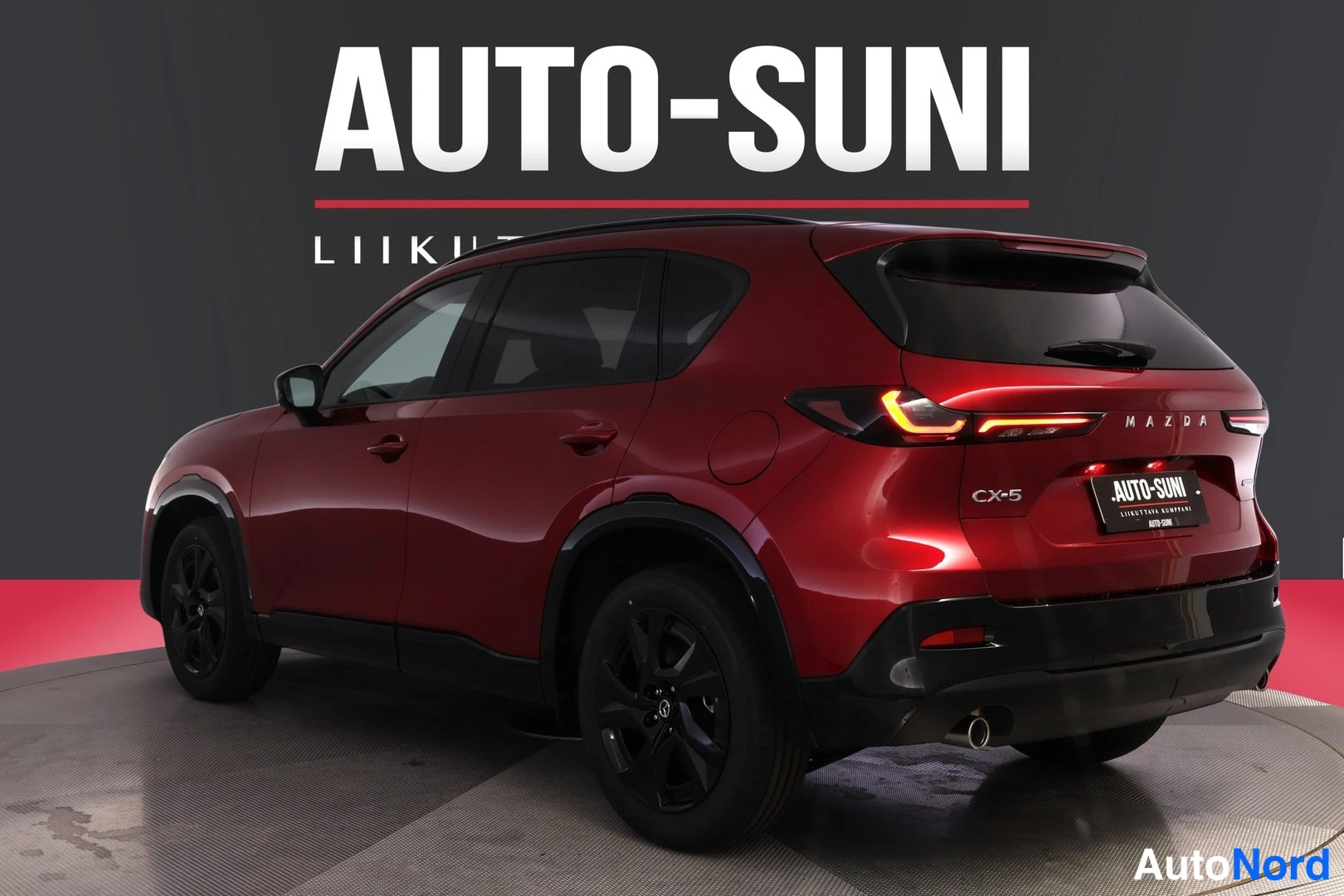 Takaviisto: Punainen Mazda CX-5 takaa toiselta kulmalta kuvattuna, CX-5-teksti ja takavalot näkyvissä.
