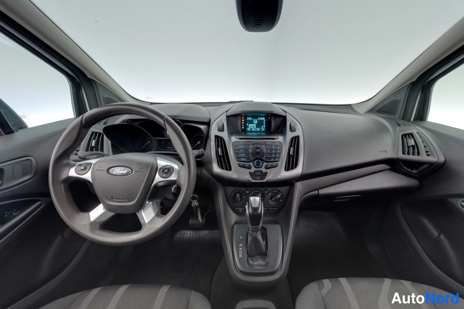 Sivulta: Auton ohjaamo: Ford-ohjauspyörä, kojelauta ja automaattivaihteiston valitsin P-R-N-D-asemilla.