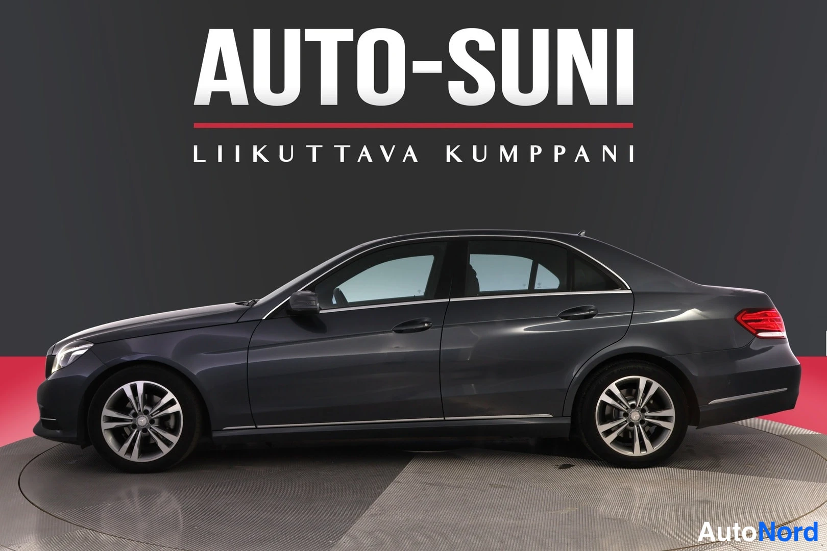 Sivulta: Mercedes-Benz E-sedanin sivuprofiili, auton vasen kylki ja koko korin sivu näkyvissä studio­taustaa vasten, yläreunassa AUTO-SUNI -mainosteksti.