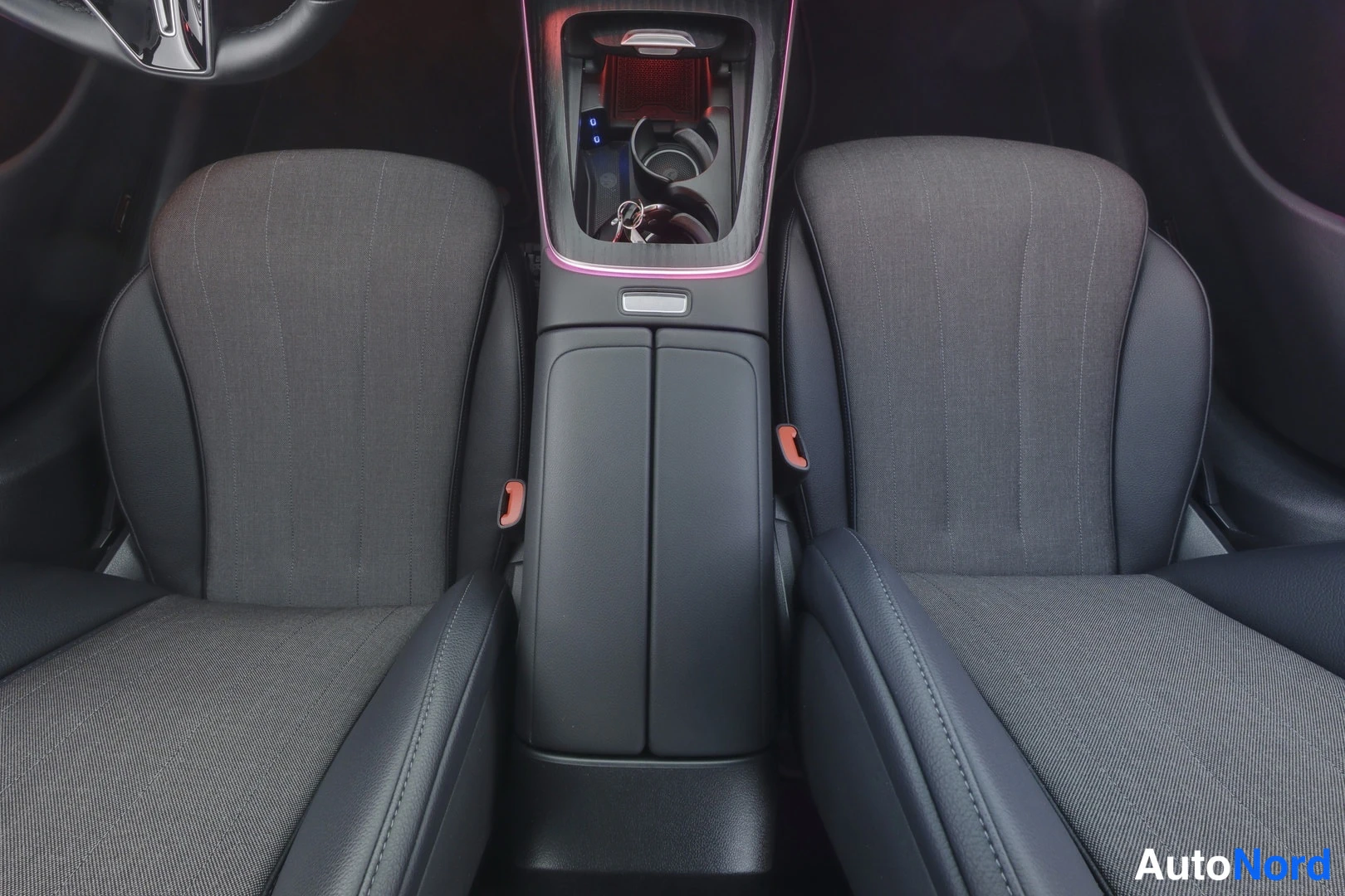 Muu: Interior view of a car's cabin with two front seats and a central console.