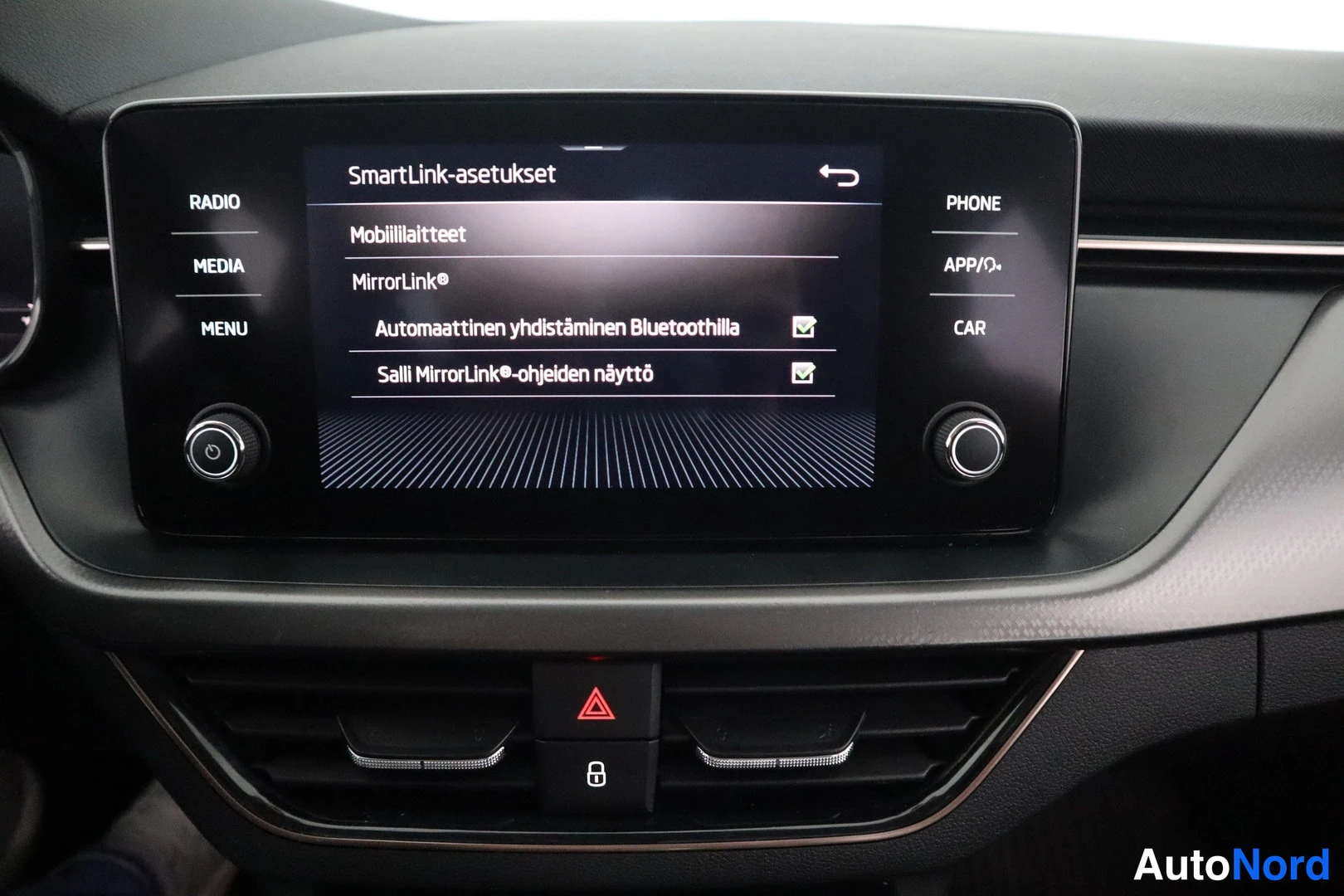 Yksityiskohta: Infotainment-näyttö, jossa näkyy SmartLink-asetukset ja Bluetooth-asetukset.