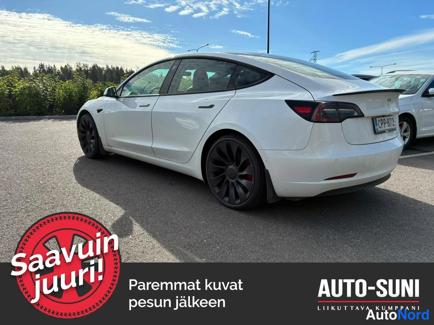 Takaviisto: Valkoinen sedan takaosan ja oikean kyljen kolmesta neljäsosasta, tummat kevytmetallivanteet ja punainen jarrusatanäkyvissä.