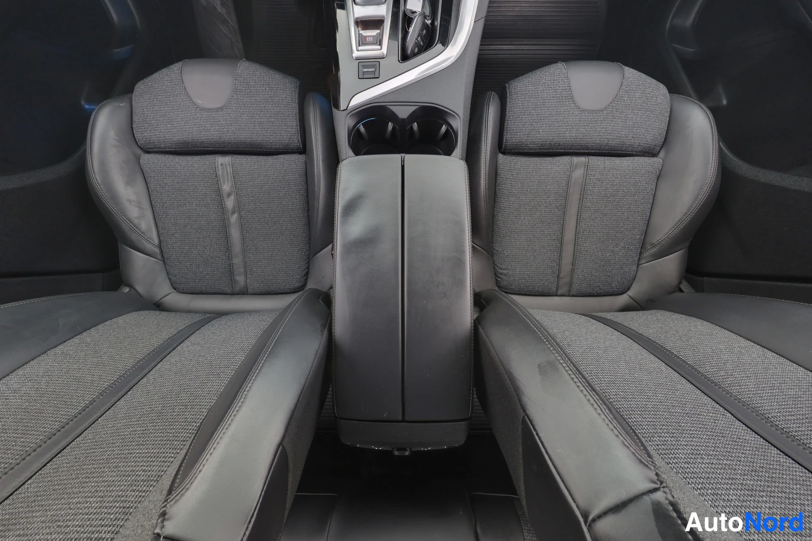 Muu: Auton takapenkun kaksi istuinta ja keskikäsi tuen taakse kuvattu sisätila.