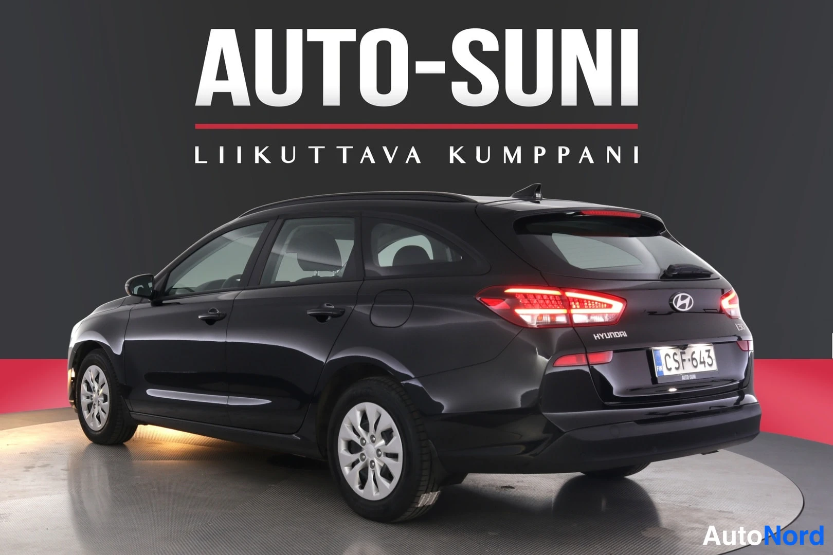 Takaviisto: Musta Hyundai i30 -farmari takaviistosta toiselta sivulta, takavalot ja rekisterikilpi näkyvissä.