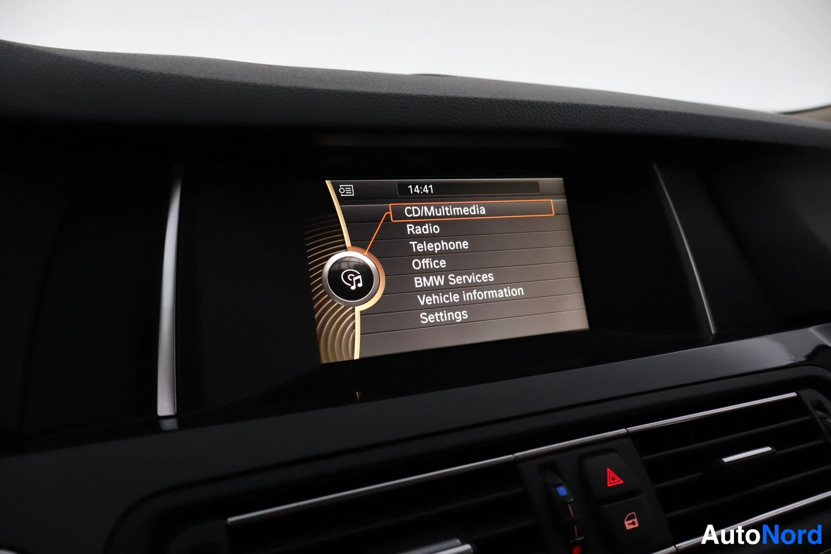 Yksityiskohta: Kojelaudan keskellä infotainmentnäyttö, jonka valikossa CD/Multimedia, Radio, Telephone, Office, BMW Services, Vehicle information ja Settings; kello 14:41.